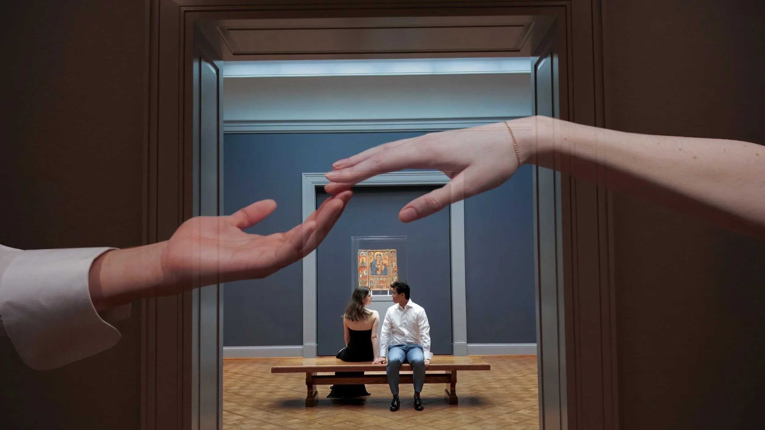 a couple sitting next to each other in an art museum with art behind them