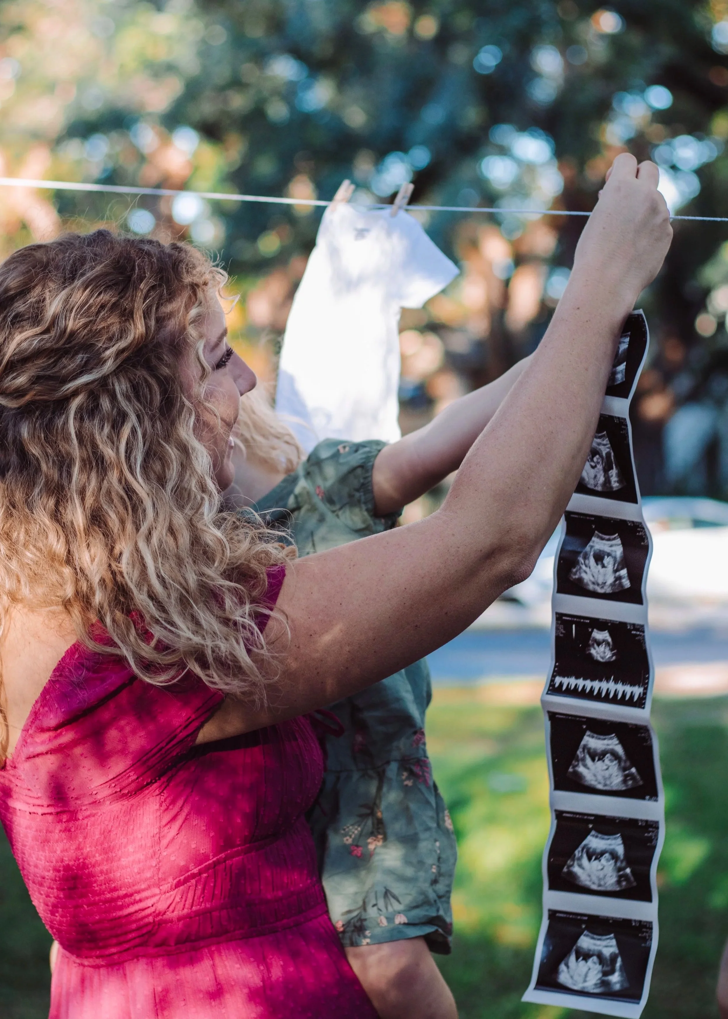 Chicago maternity photographer capturing a mother and child hanging ultrasound photos on a clothesline, meaningful and candid maternity moment celebrating pregnancy and family

