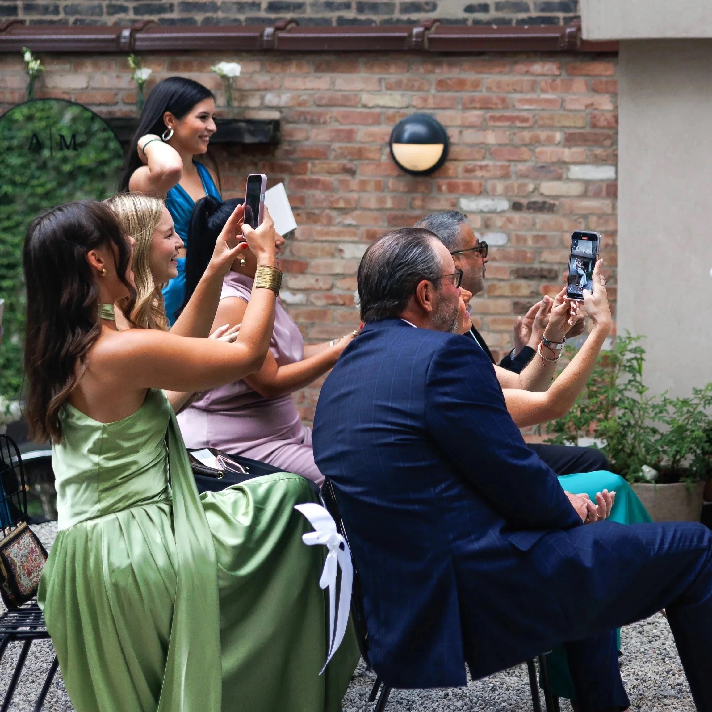 7 wedding guests taking photos of the groom carrying the bride off