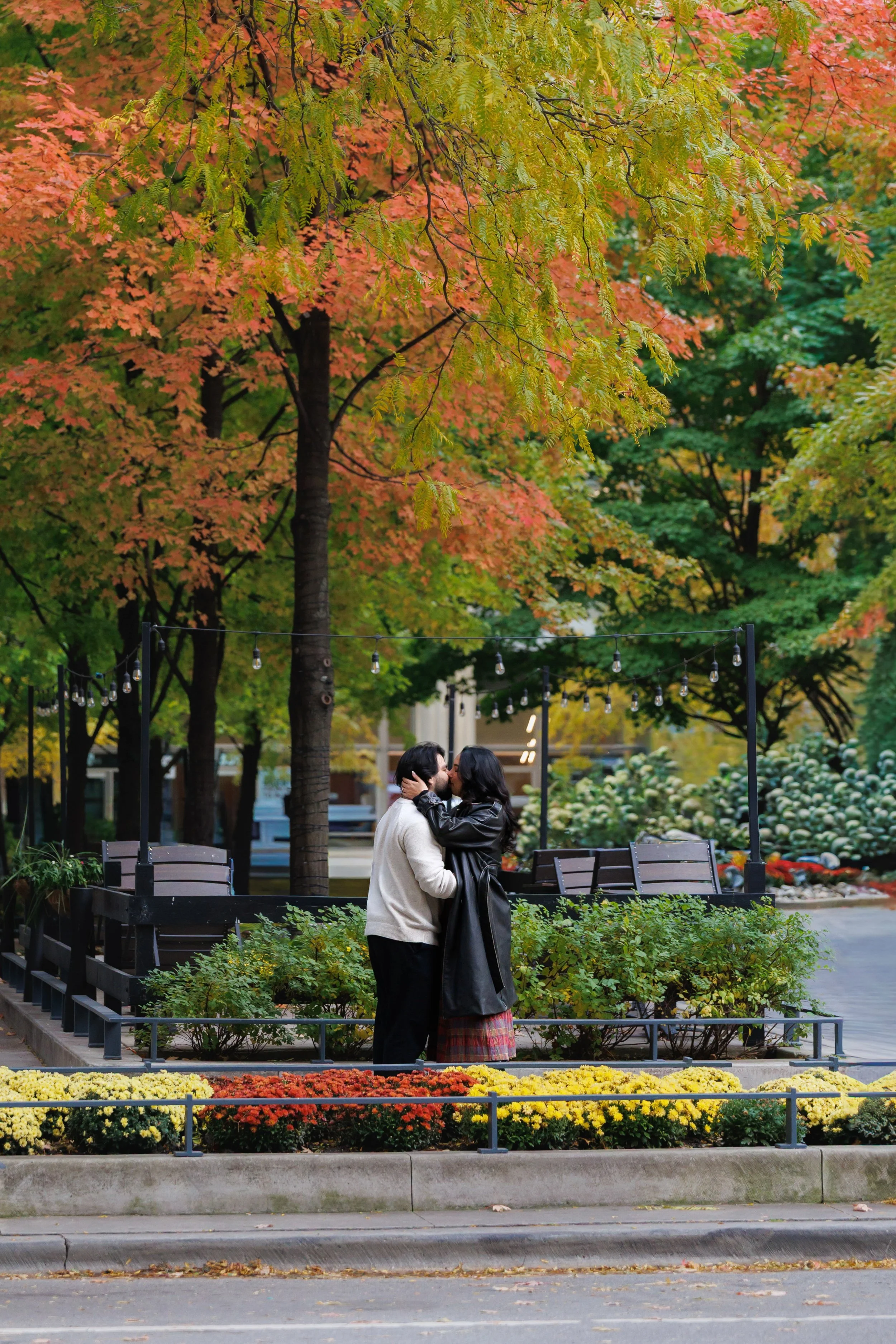Couple embracing outdoors during fall engagement session in Chicago with warm tones and natural movement