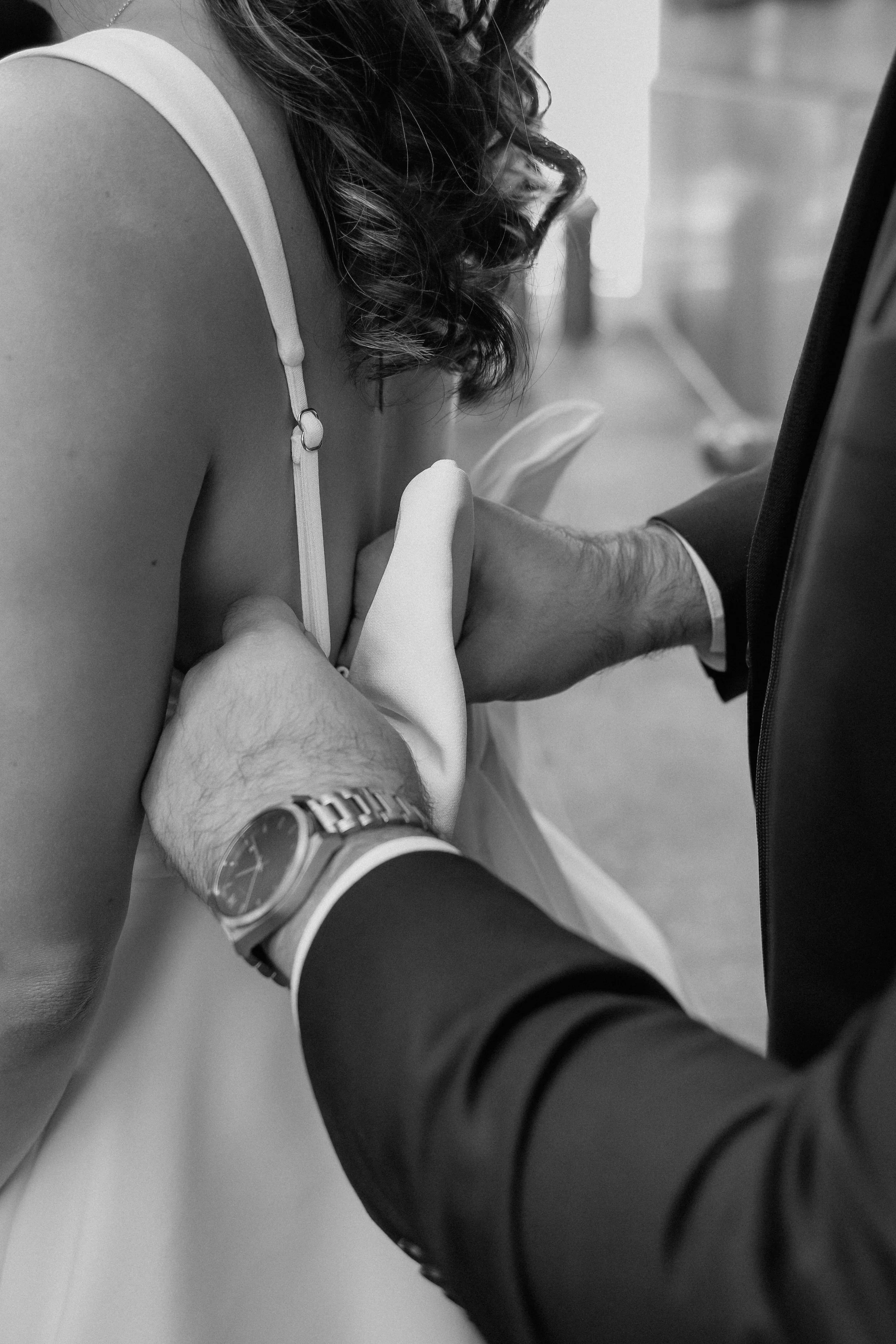 A wedding ceremony where a man in a suit and a woman in a wedding dress are holding hands, exchanging vows, with the woman’s curly hair visible. Chicago wedding photographer