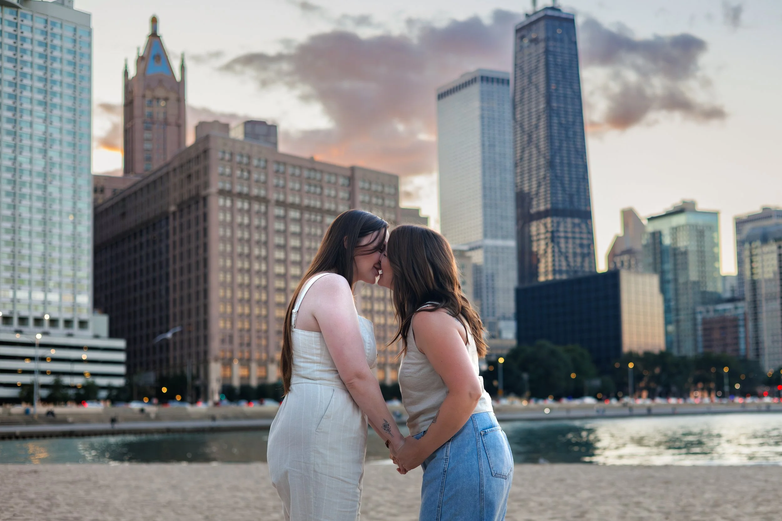 Chicago photographer captures a couple kissing in front of the downtown skyline while on the beach