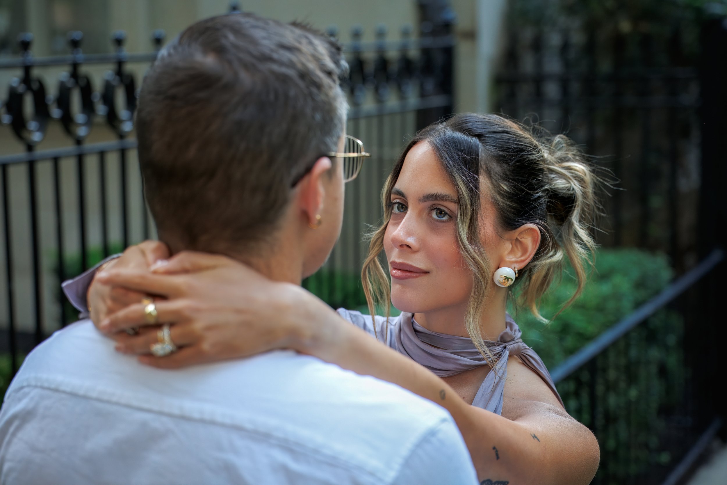 Chicago photographer capturing a couple in formal attire embracing on a staircase, woman in white dress, elegant and timeless engagement portrait with natural light.
