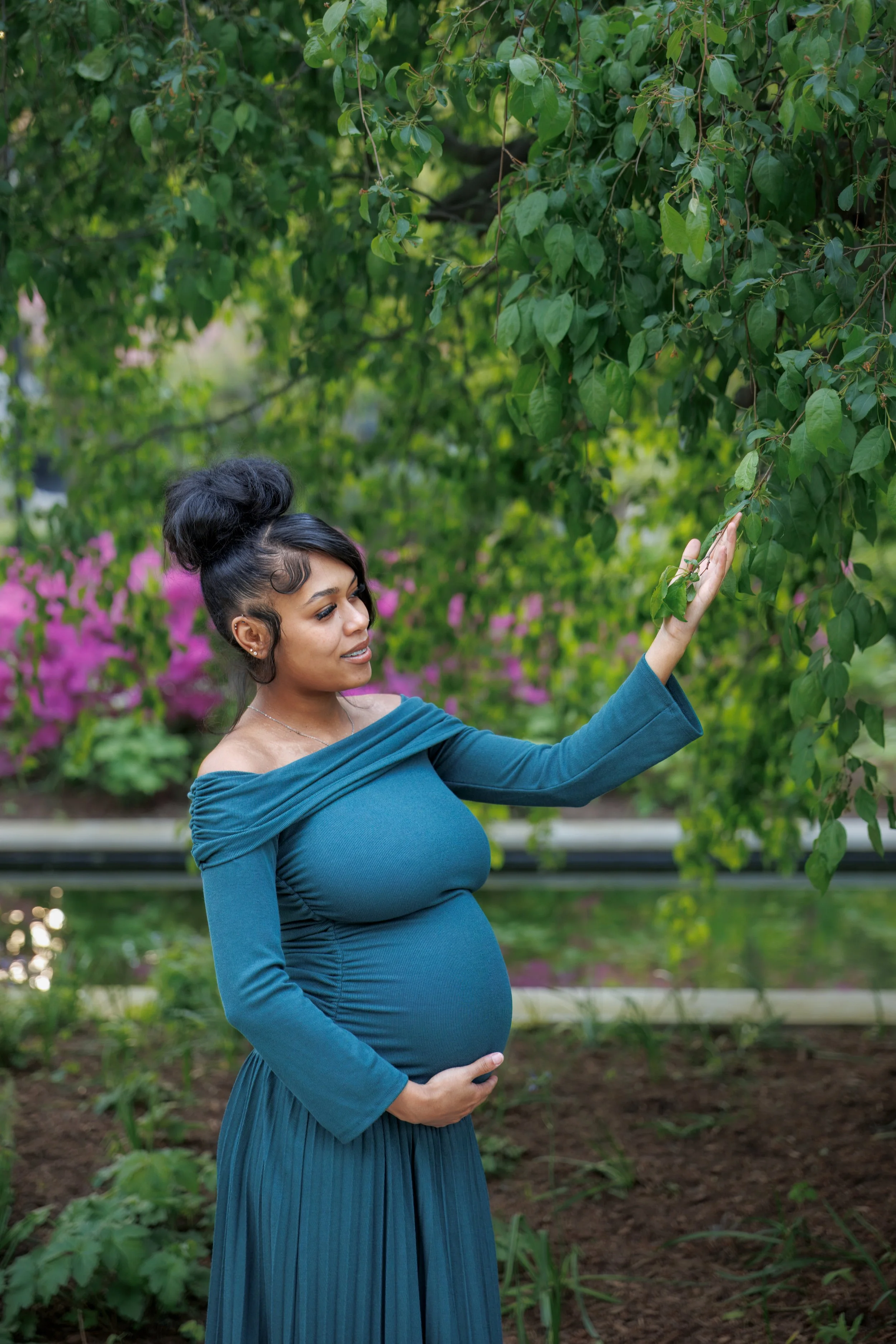 Chicago photographer capturing a pregnant woman in a garden looking at a tree