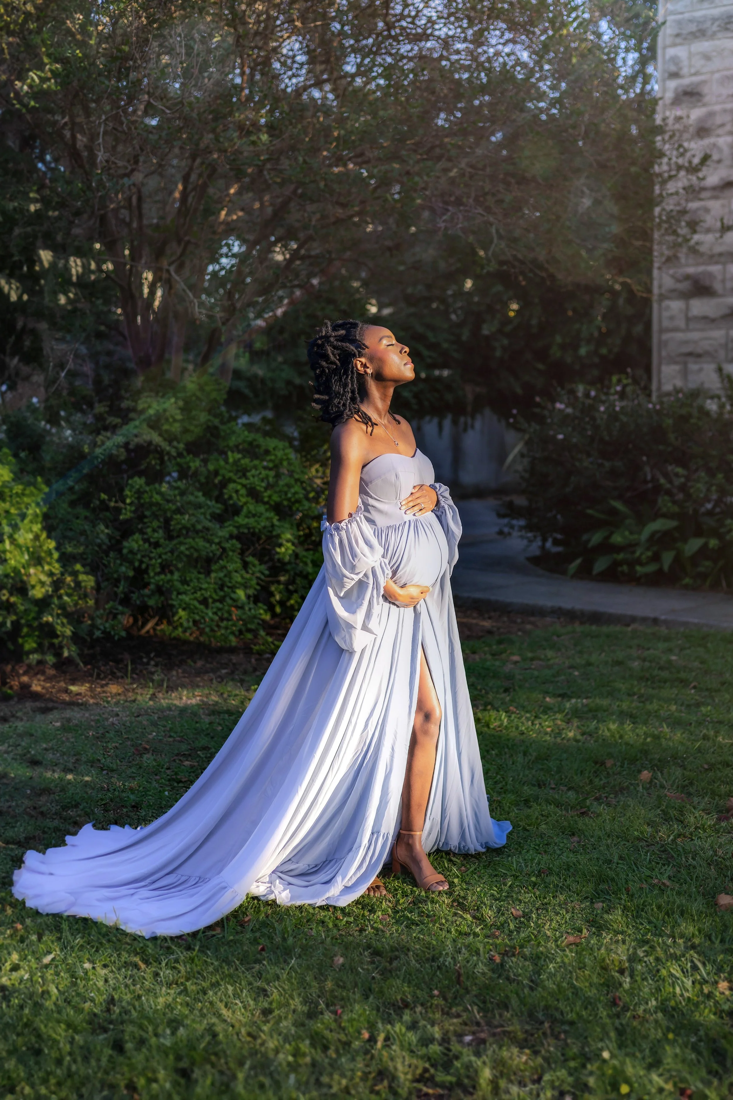 Chicago maternity photographer capturing a pregnant woman in a white lace dress standing beside a tree, peaceful and intimate outdoor maternity portrait with natural light