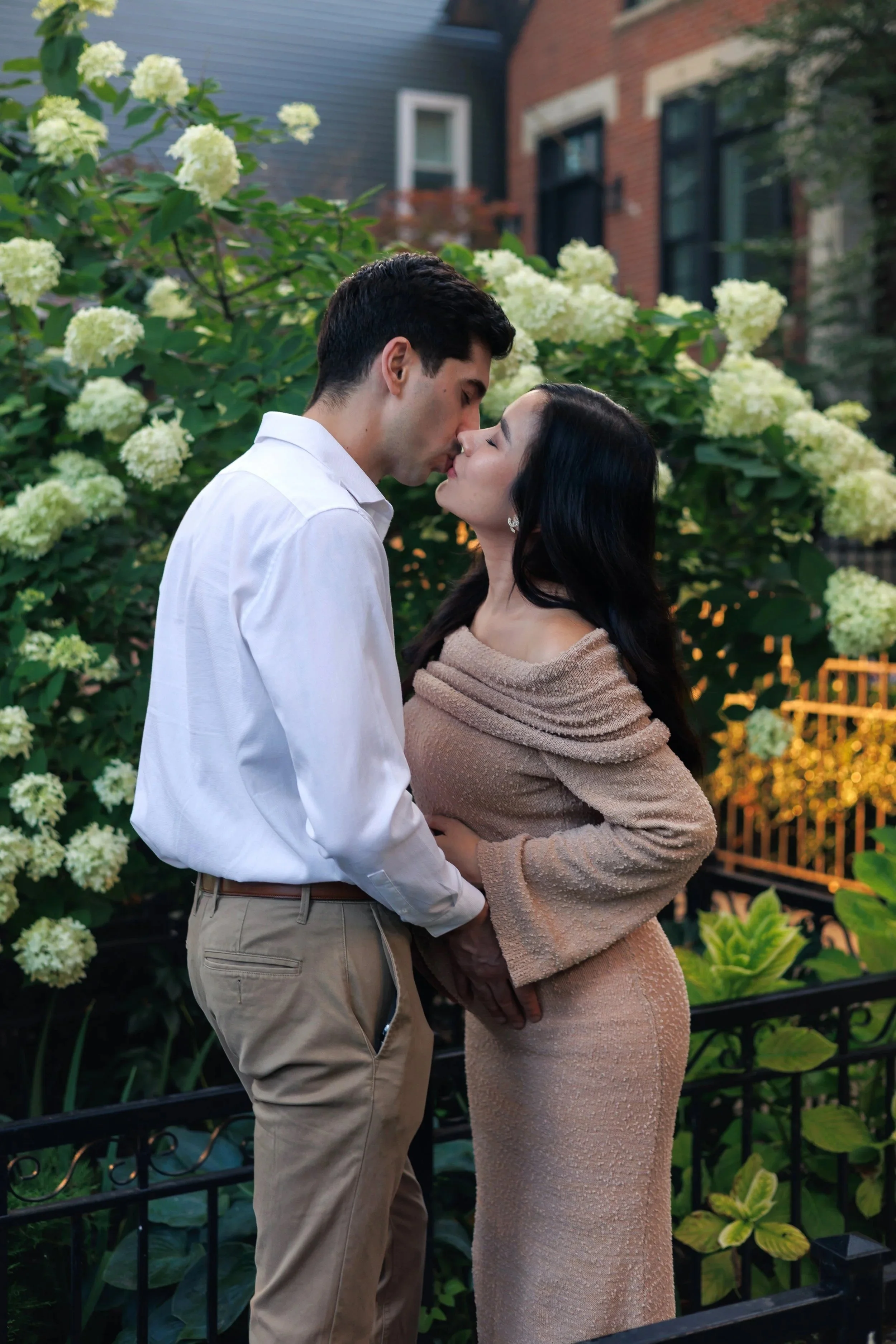 Chicago maternity photographer capturing a couple walking hand in hand on outdoor steps, woman in a flowing blue dress, romantic and candid maternity session with natural light