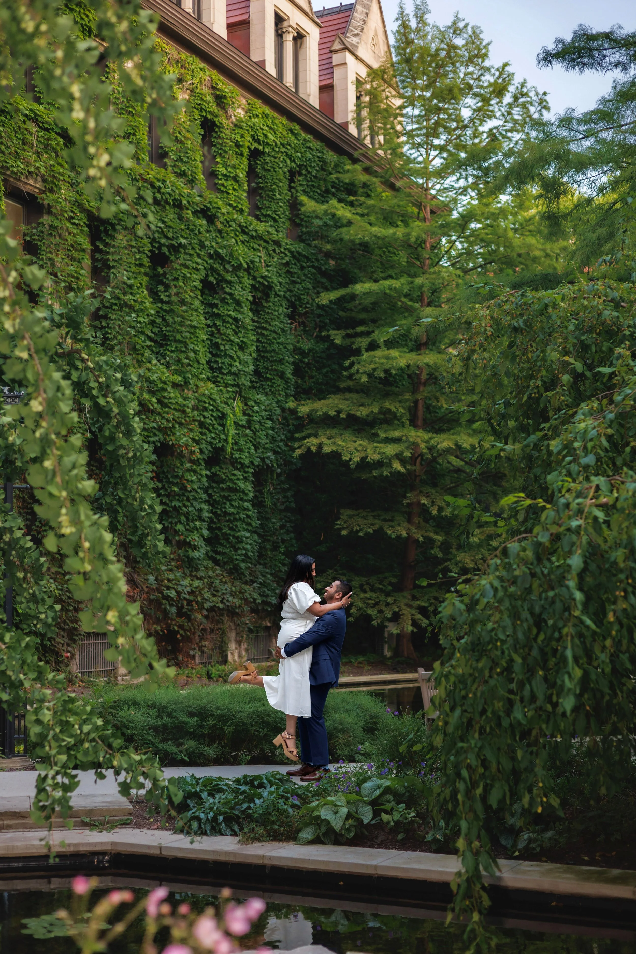 Couple embracing in front of ivy-covered wall at University of Chicago during engagement session