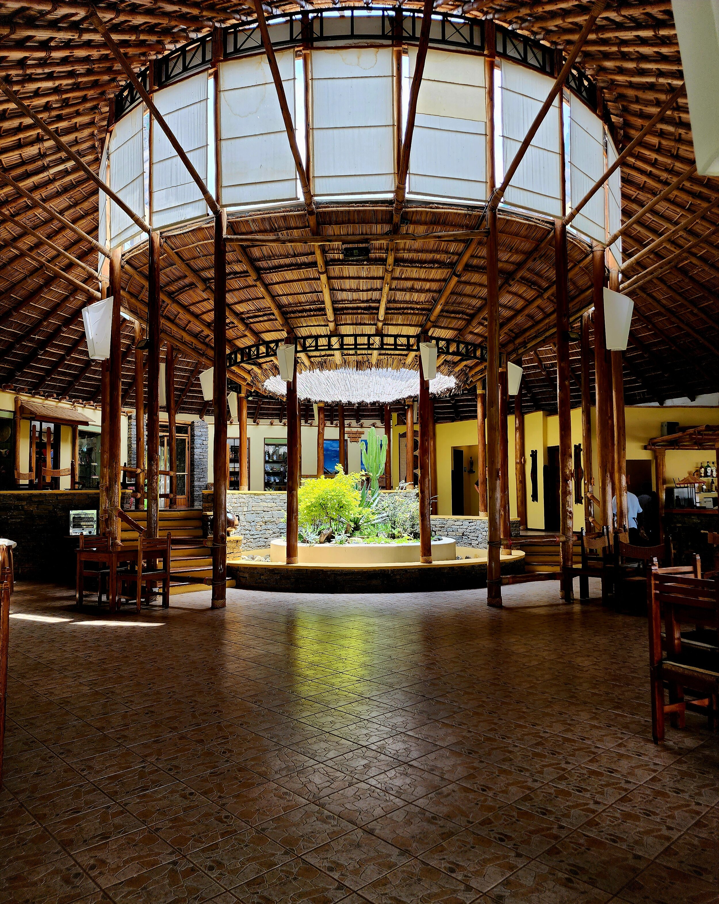 Interior of a tropical-style restaurant with wooden beams and a circular design in Ethiopia.