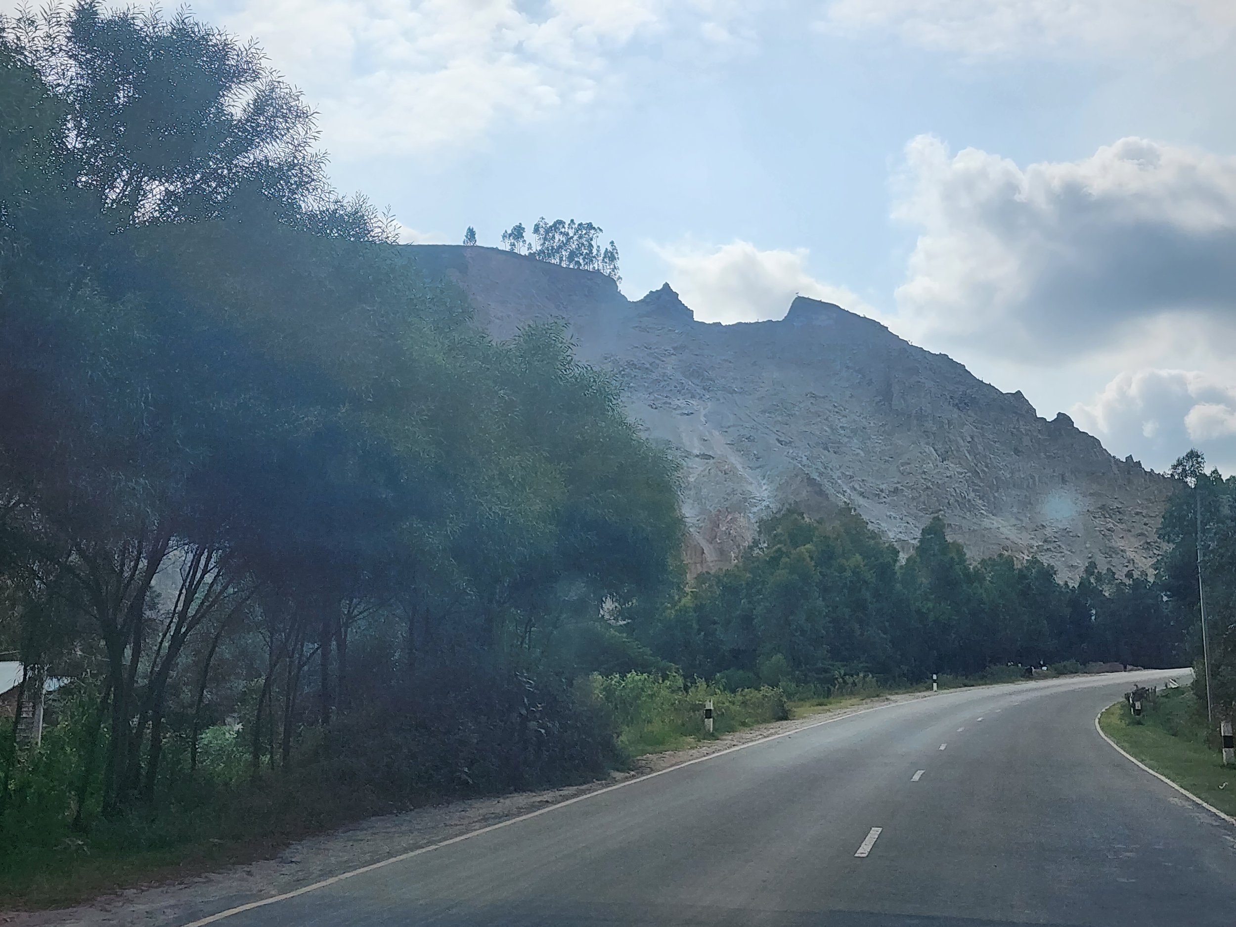 Mountain road landscape with trees and blue sky in Ethiopia.