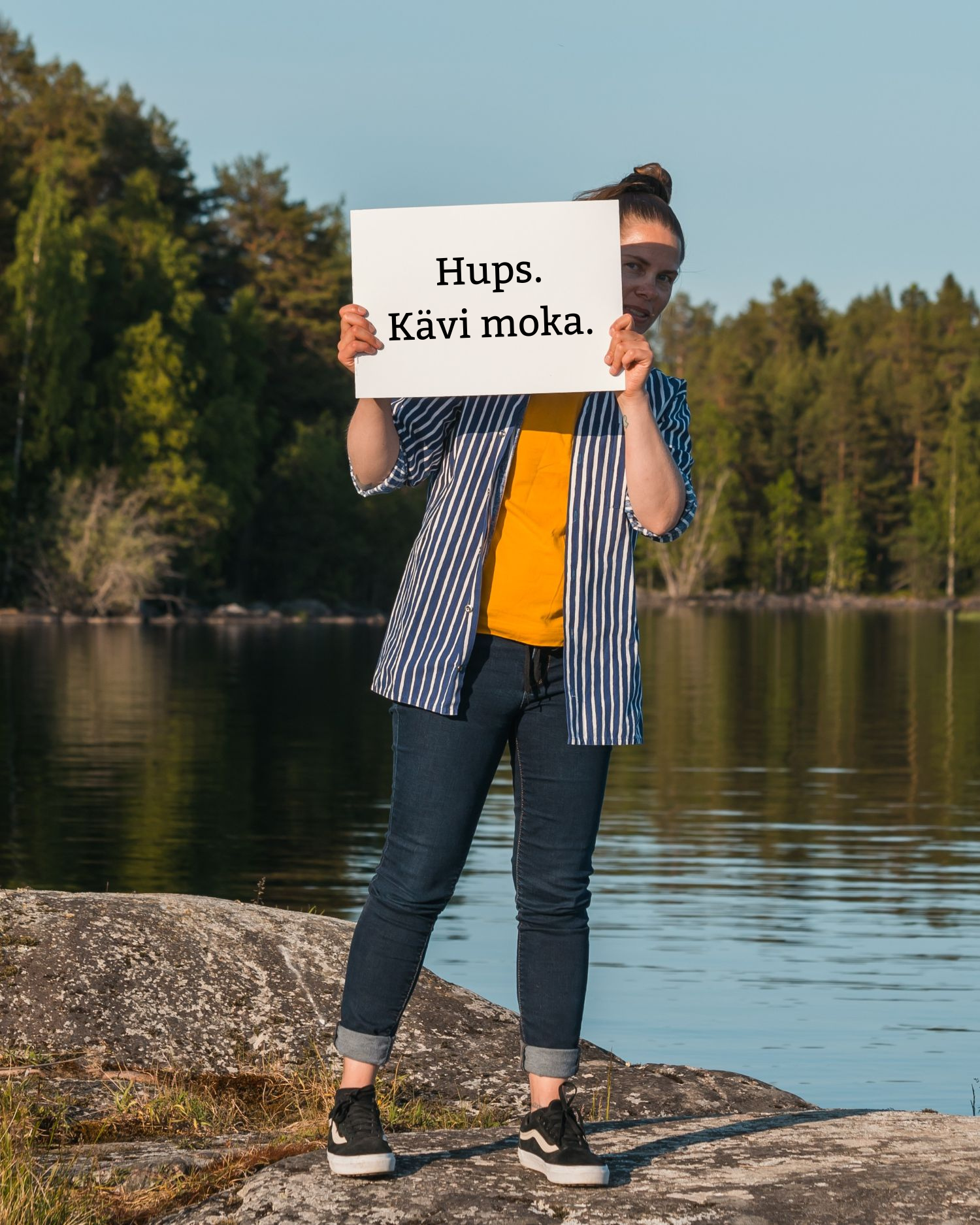Henkilö pitää käsissään lappua, jonka takaa kurkistaa. Lapussa lukee "Hups. Kävi moka."