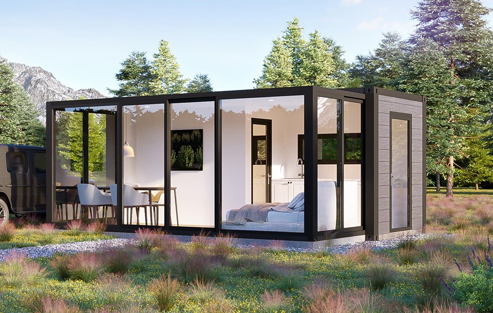 Modern tiny house with glass walls in a natural setting, featuring trees and mountains in the background.