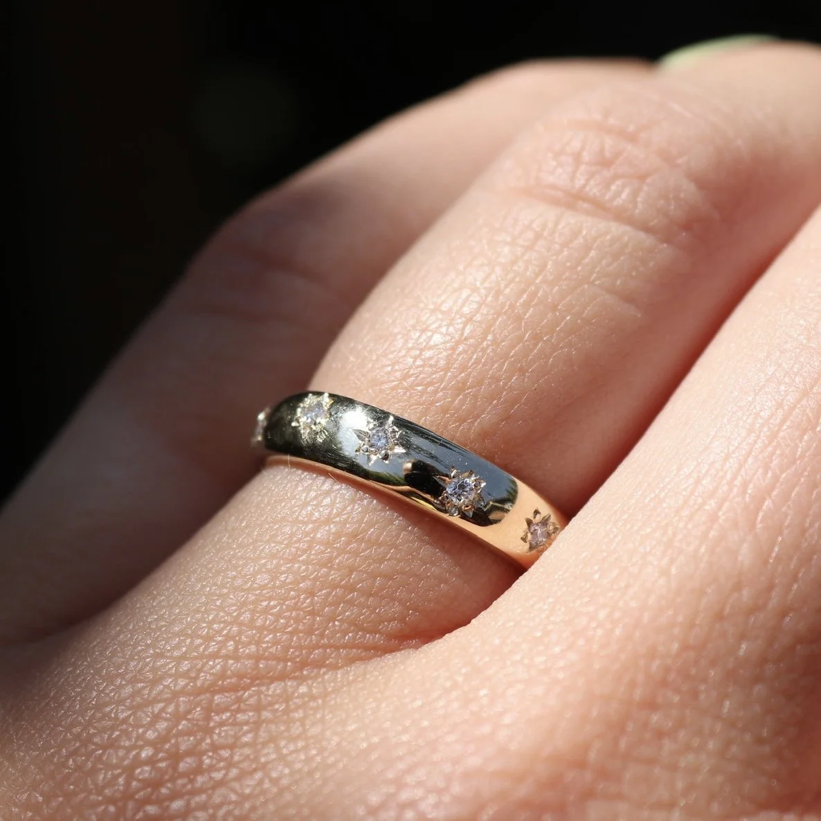 A bespoke 9ct yellow gold star set wedding band with hidden birthstones set inside the band.