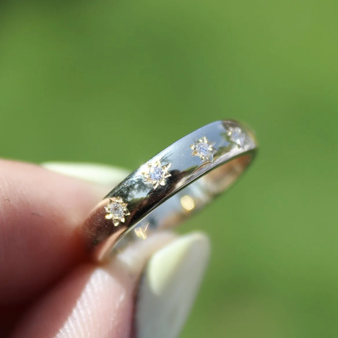 A bespoke 9ct yellow gold star set wedding band with hidden birthstones set inside the band.