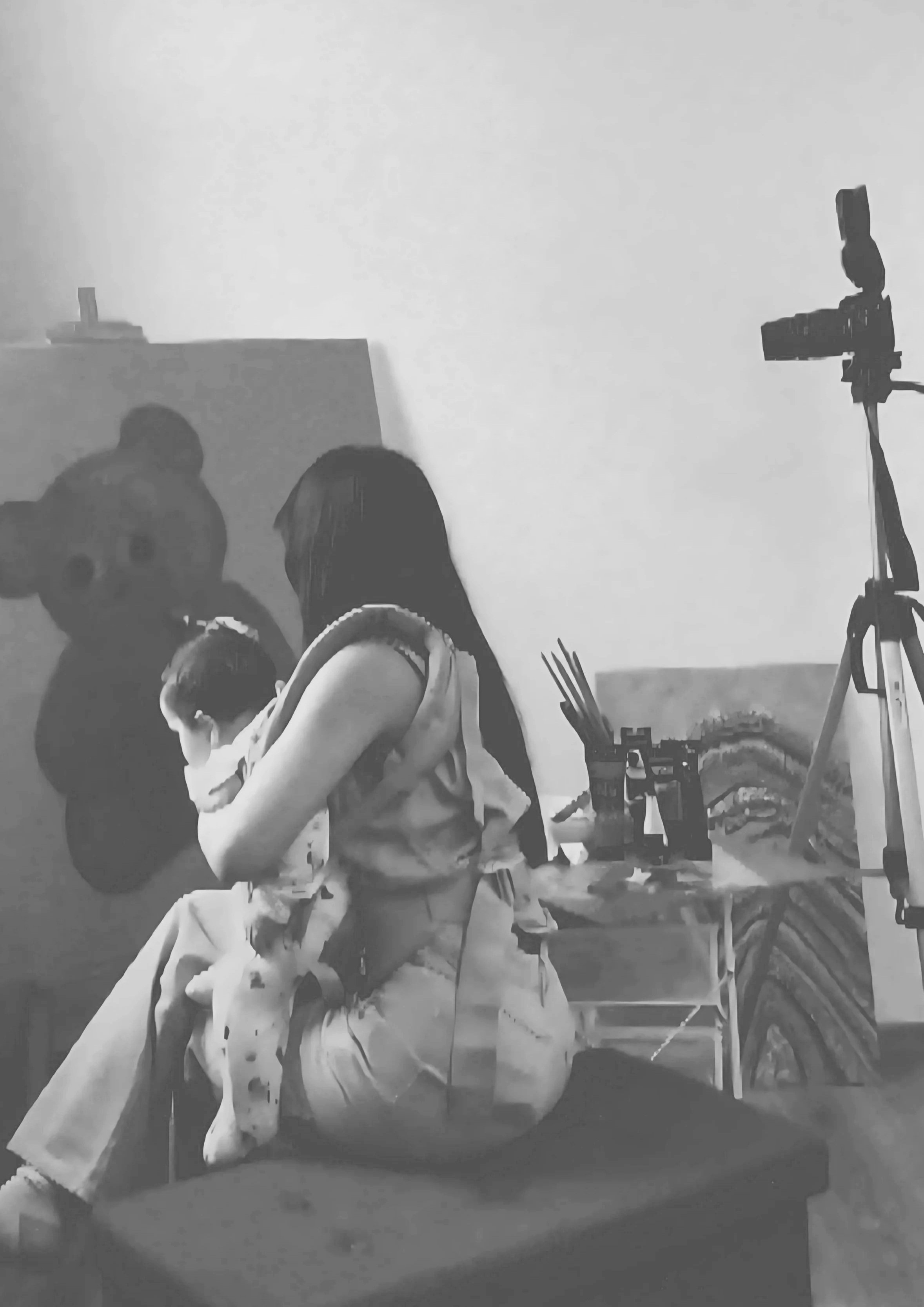 with her daughter being carried Artist Mayssam working in her studio on a textured mixed media artwork, capturing the creative process behind mKunstraum