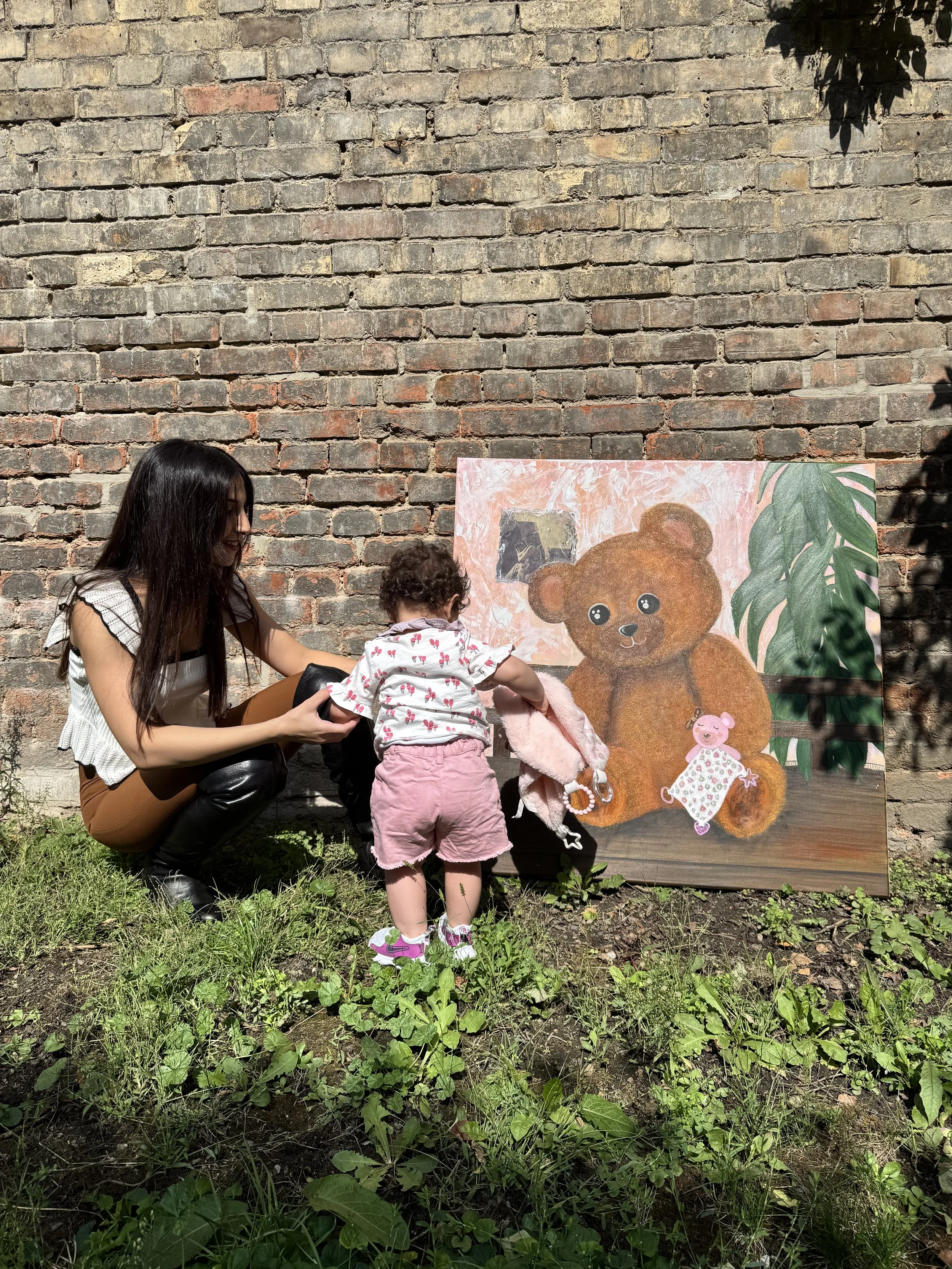 Artist Mayssam with her daught infront of her Master inspirational piece of her Sacred Hugs collection reflecting the beautiful bond between mother and daughter