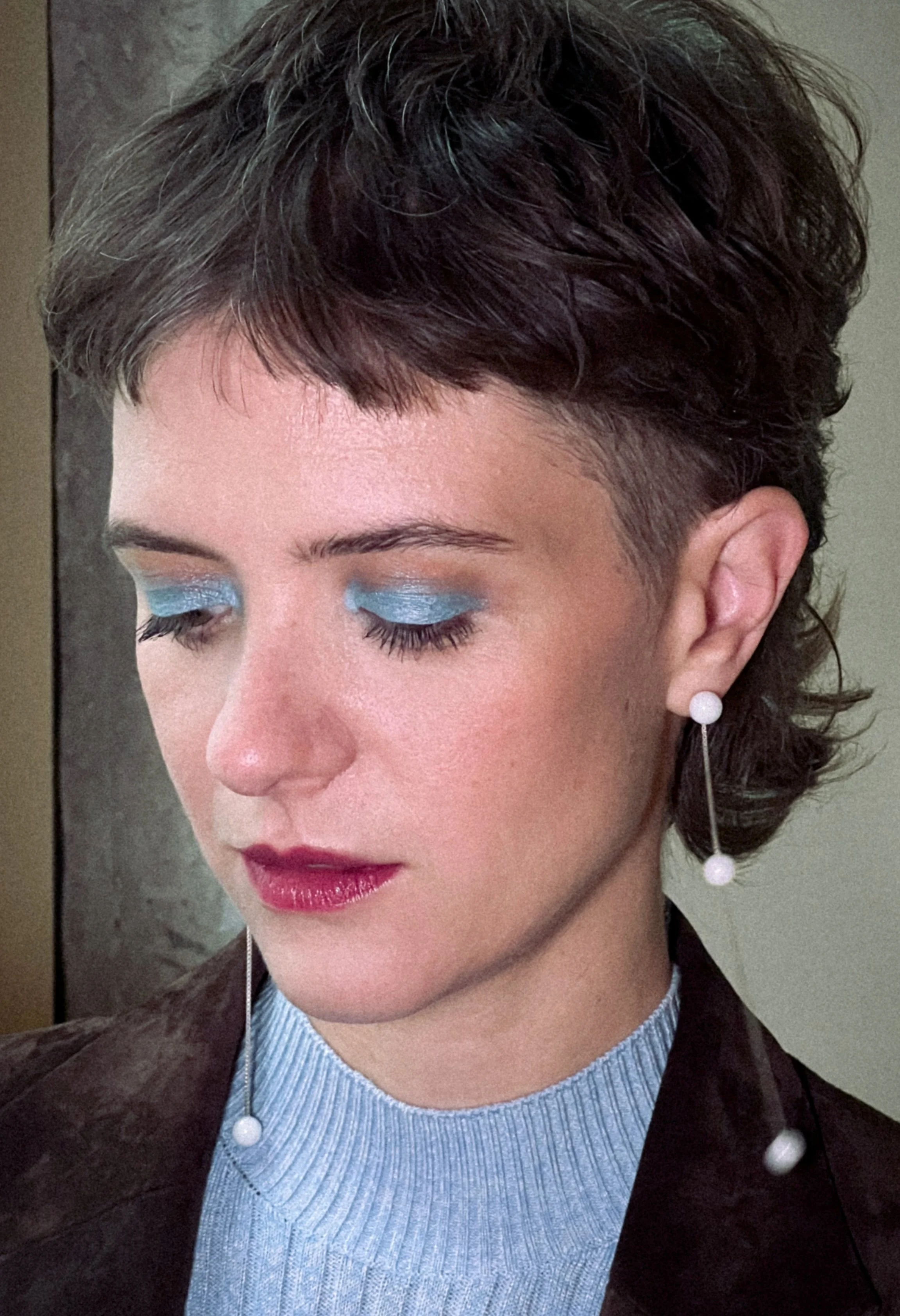 Schauspielerin Liv Lisa Fries, bekannt in ihrer Rolle der Charlotte Ritter in der deutschen Serie Babylon Berlin, mit glamourösem, farbenfrohem Make-Up.