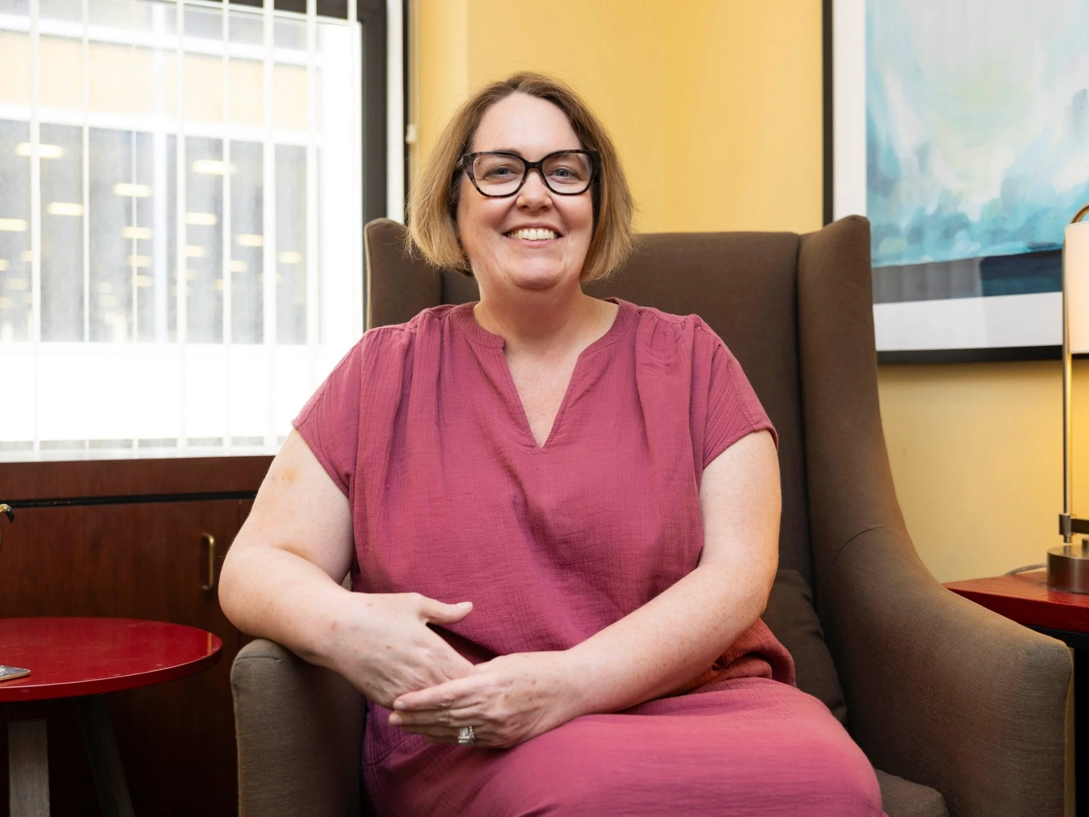 photo of Rachel Sykes, therapist, smiling wearing a pink dress