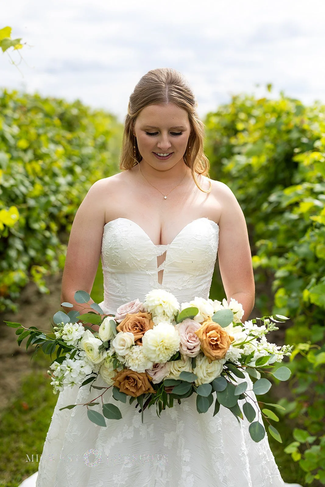 Four Daughters Vineyard & Winery wedding featuring a lush bridal bouquet in creamy whites, soft pinks, and unexpected brown blooms, with romantic wedding florals in Spring Valley, MN.
