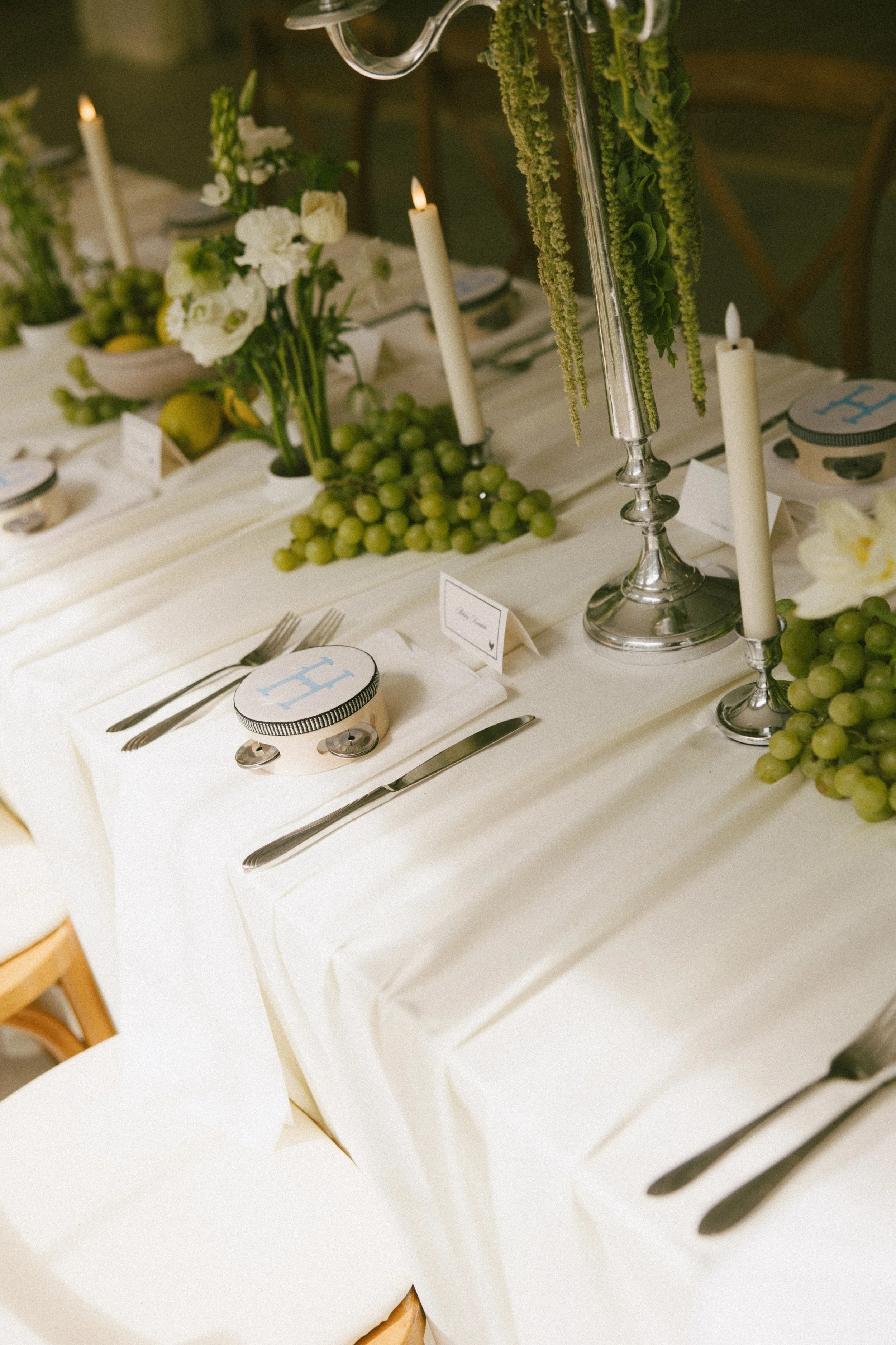 This Hilltop House wedding in Rochester, Minnesota was all about the details: airy garden-inspired florals, old-world candlelight, soft white linens, and those gorgeous little clusters of green grapes winding their way down the table.