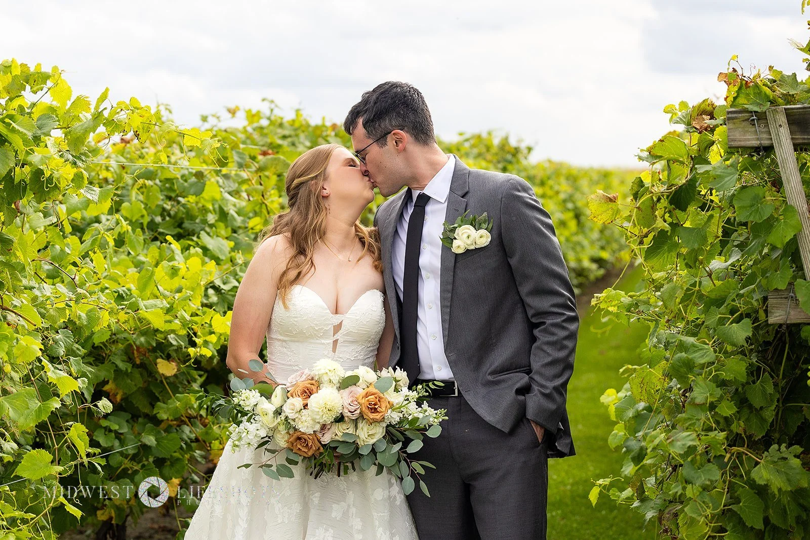 Four Daughters Vineyard & Winery wedding featuring a lush bridal bouquet in creamy whites, soft pinks, and unexpected brown blooms, with romantic wedding florals in Spring Valley, MN.
