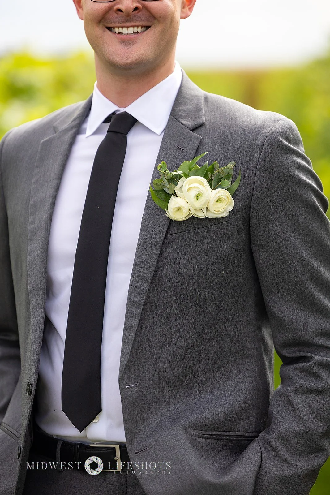 Four Daughters Vineyard & Winery wedding featuring a modern pocket boutonniere with ranunculus and romantic greenery in Spring Valley, MN.