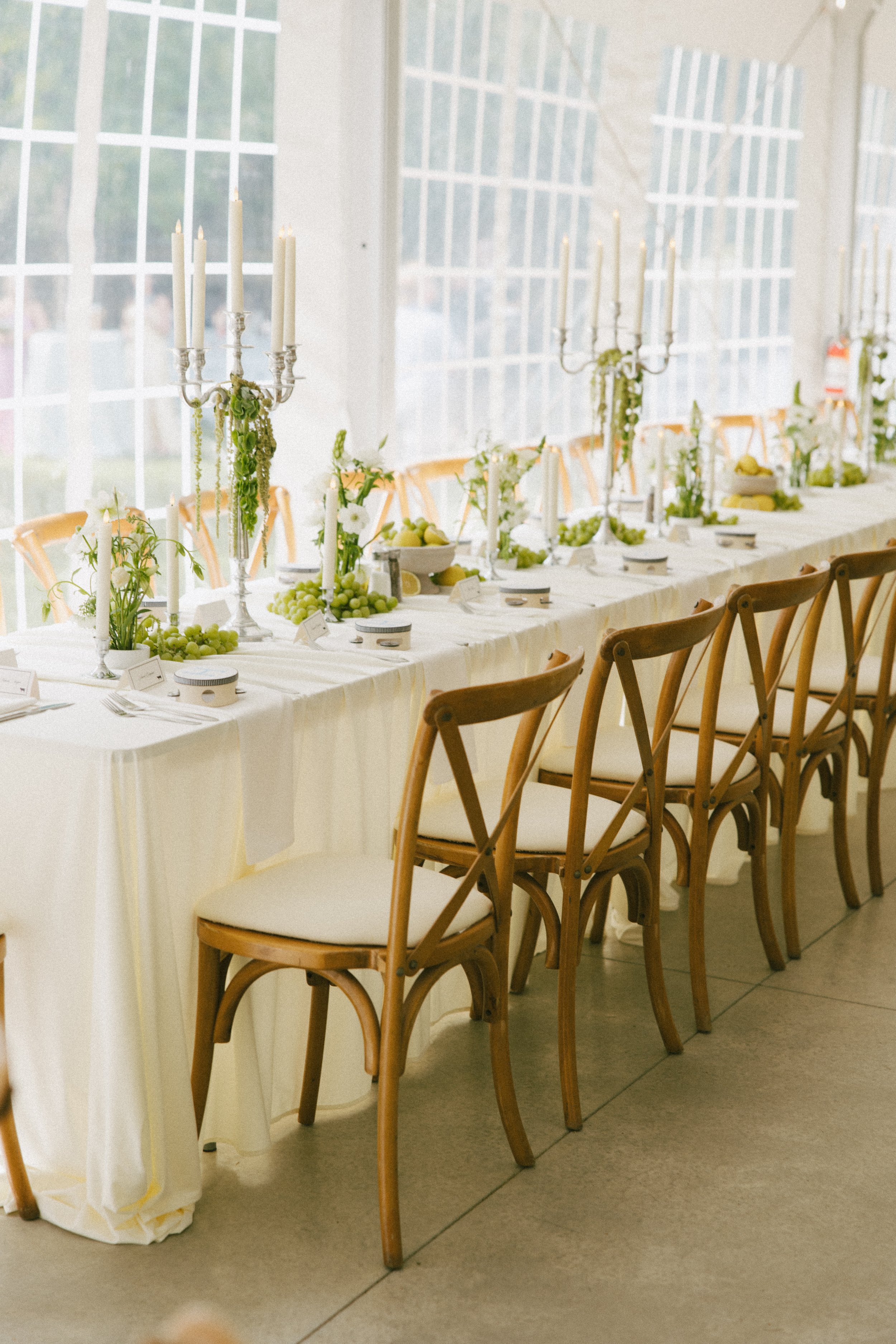 This Hilltop House wedding in Rochester, Minnesota was all about the details: airy garden-inspired florals, old-world candlelight, soft white linens, and those gorgeous little clusters of green grapes winding their way down the table.