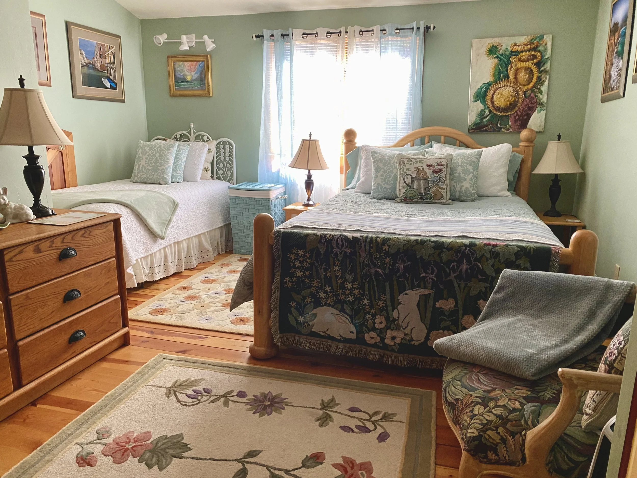 A soft green bedroom with woodland animal tapestries and floral decor.