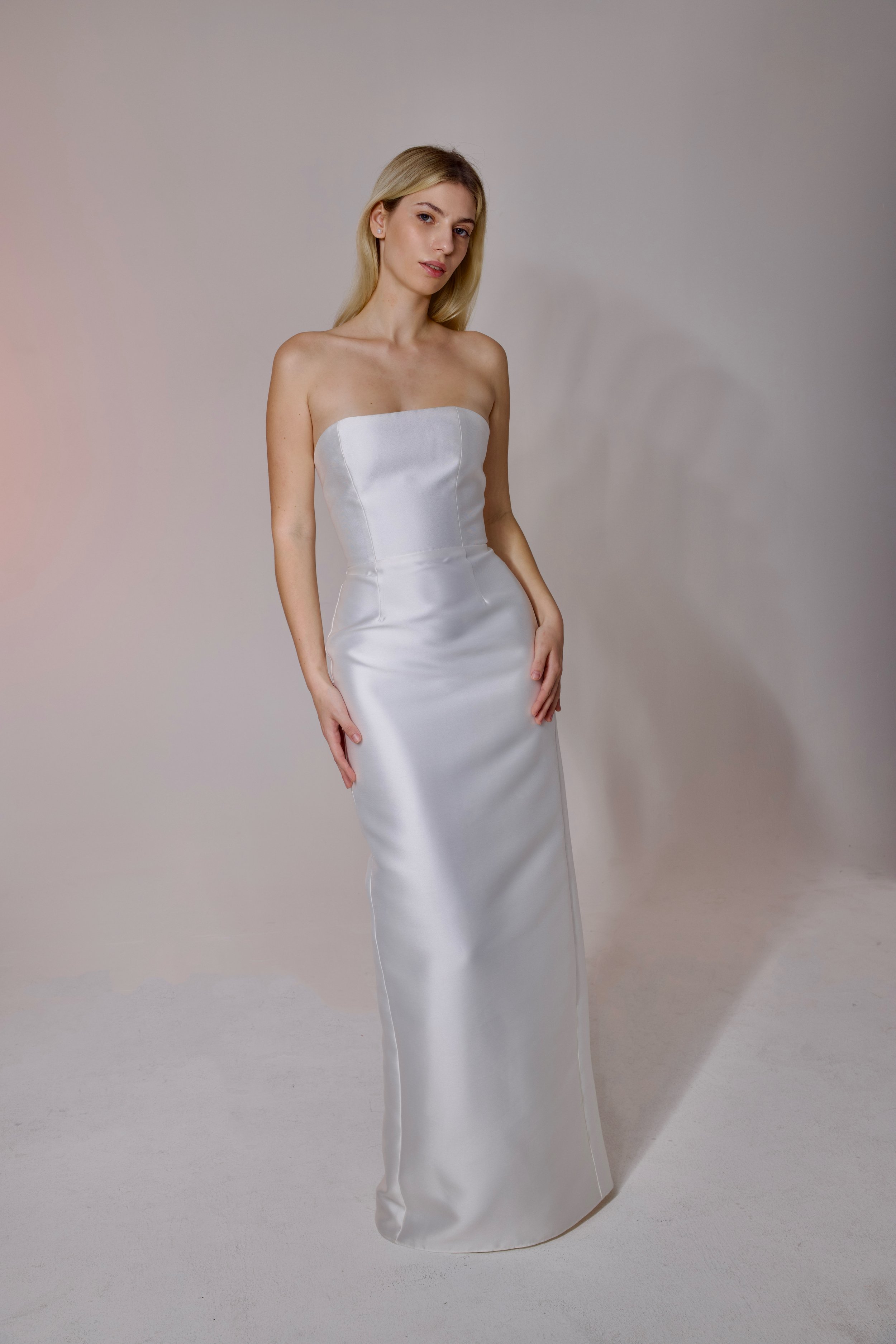Mikado fabric with a subtle shine, designed with clean lines and a straight silhouette. Finished with a detachable train for an elegant, versatile look.