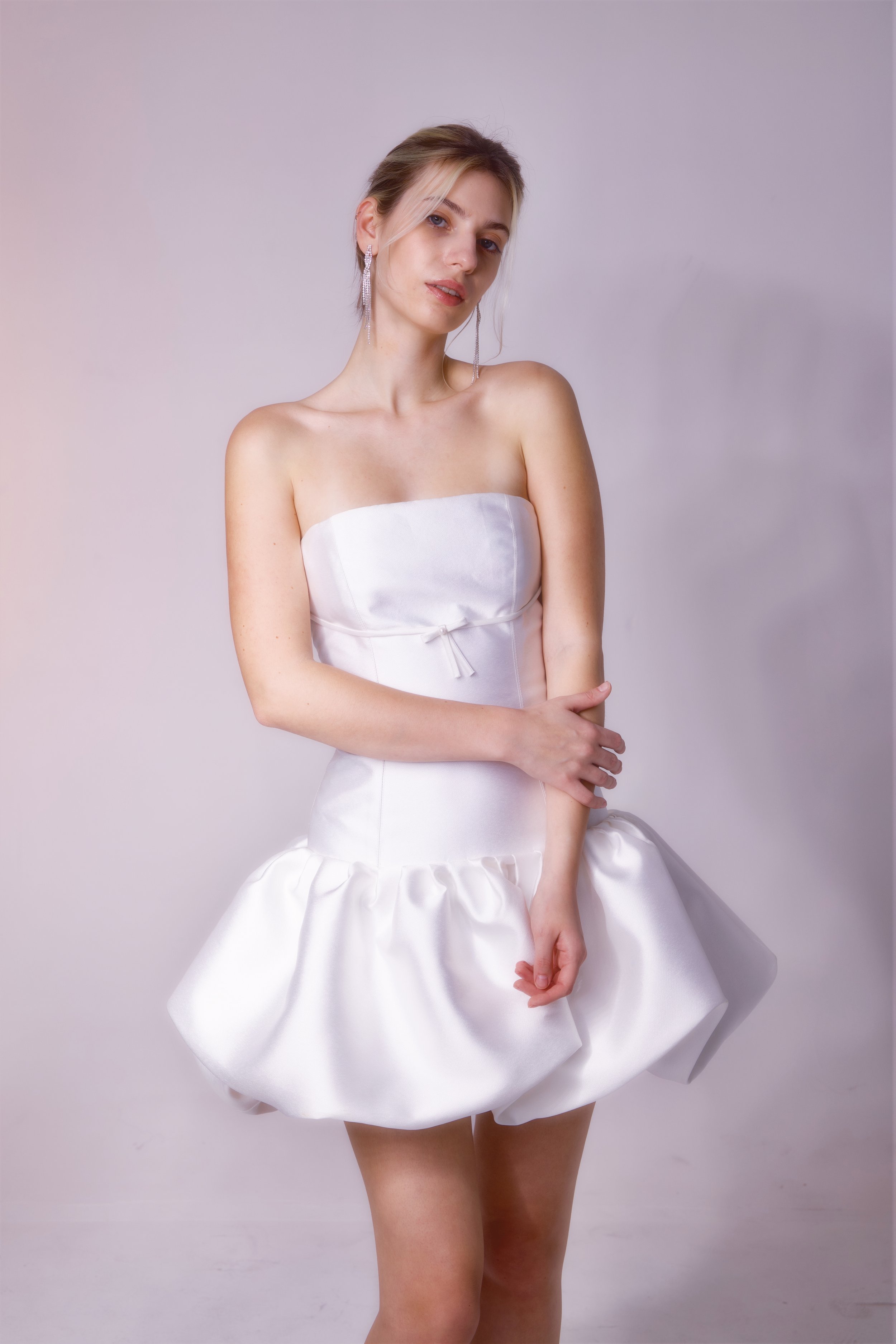The 'Pavlova' mini dress is the perfect choice for a reception, bridal shower, or engagement photos. Featuring a drop waist, playful bubble skirt, and the cutest bow detail under the bust, it’s a fun and flirty look for any bridal moment.