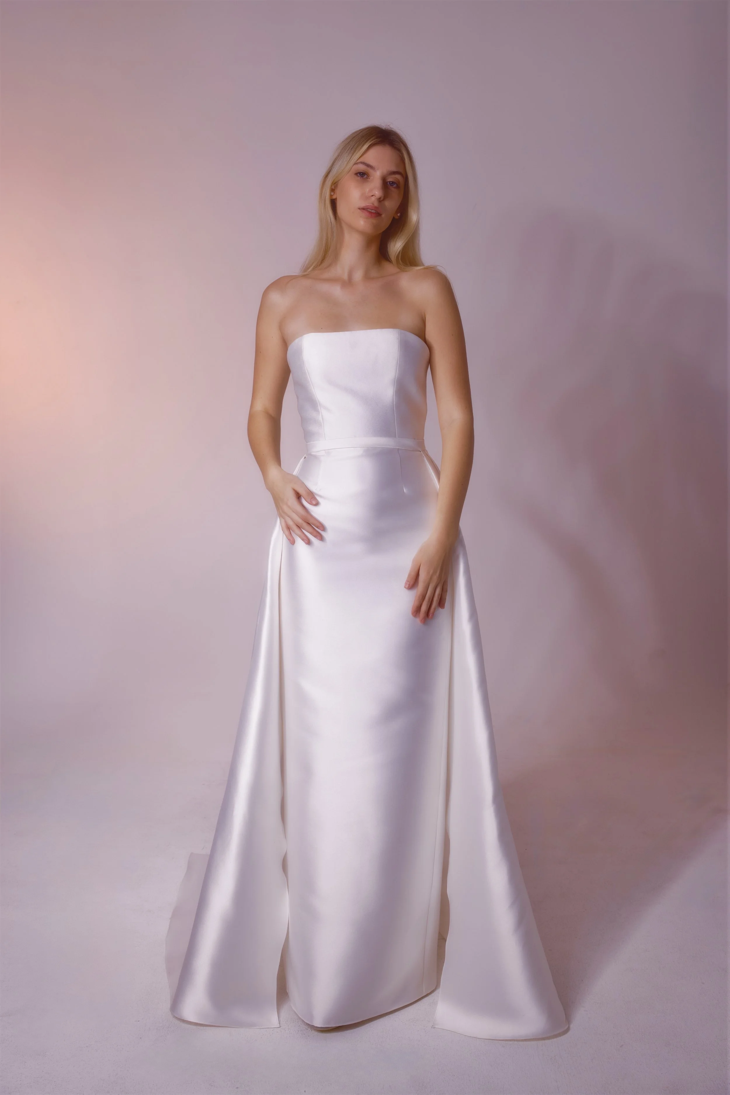 Mikado fabric with a subtle shine, designed with clean lines and a straight silhouette. Finished with a detachable train for an elegant, versatile look.