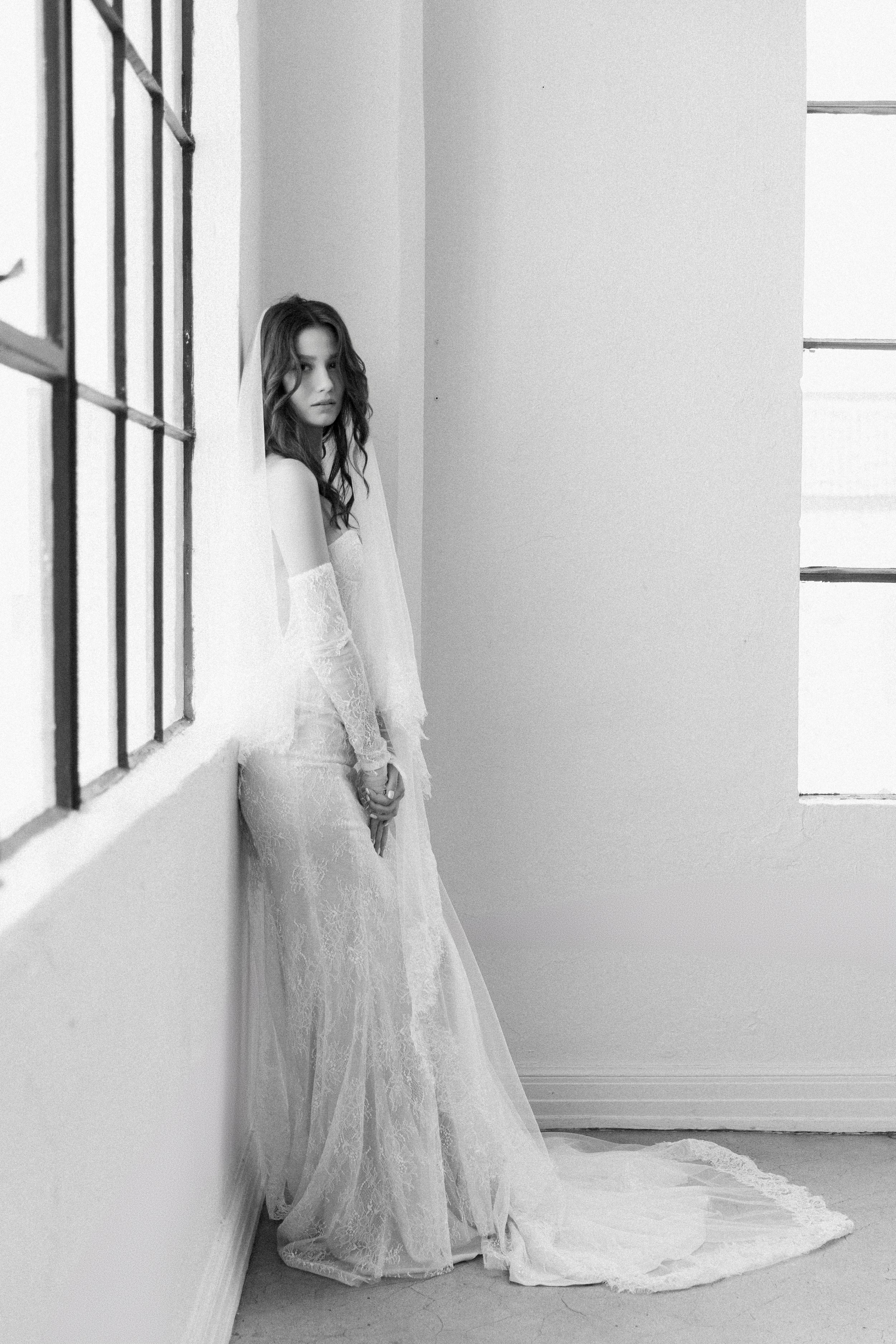 Chantilly lace and georgette silk dress featuring a fitted silhouette. Designed with a sheer mesh back that creates a backless illusion, and finished with detachable sleeves for versatile styling.