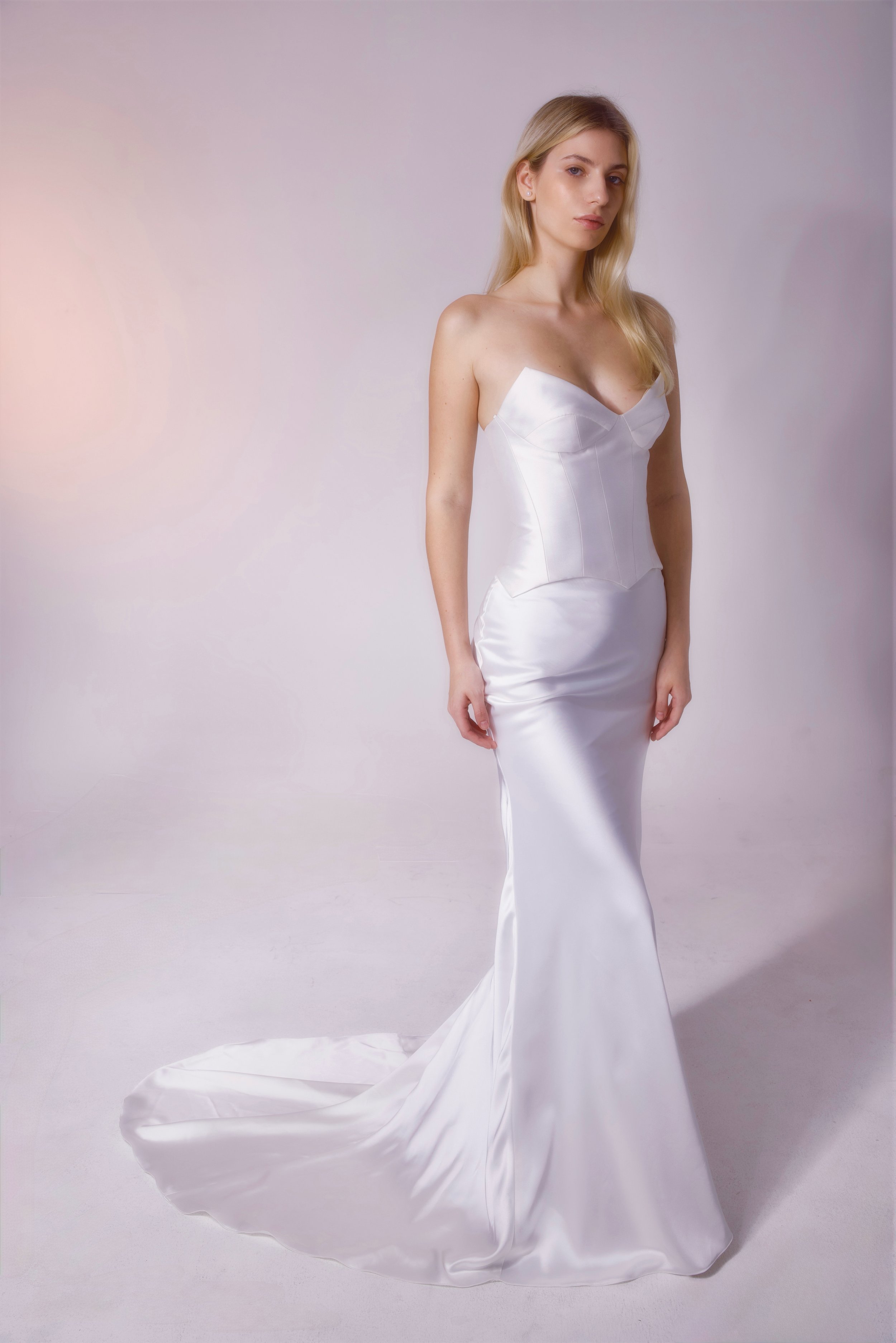 The 'Loranza' gown is a sophisticated two-piece set featuring an Italian satin skirt and a structured Mikado corset bodice. With its chic cat-eye neckline and sleek silhouette, this look strikes the perfect balance between modern elegance and timeles