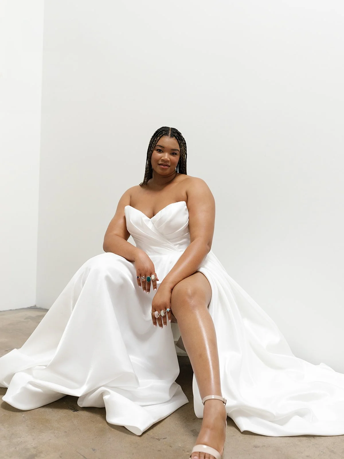 Luxurious classic A-line silhouette dress. The dress has a sweetheart neckline, draping, and a high leg slit. The beautiful satin fabric and detailed back makes for a timeless yet flirty look! Option to order with or without detachable sleeves and le