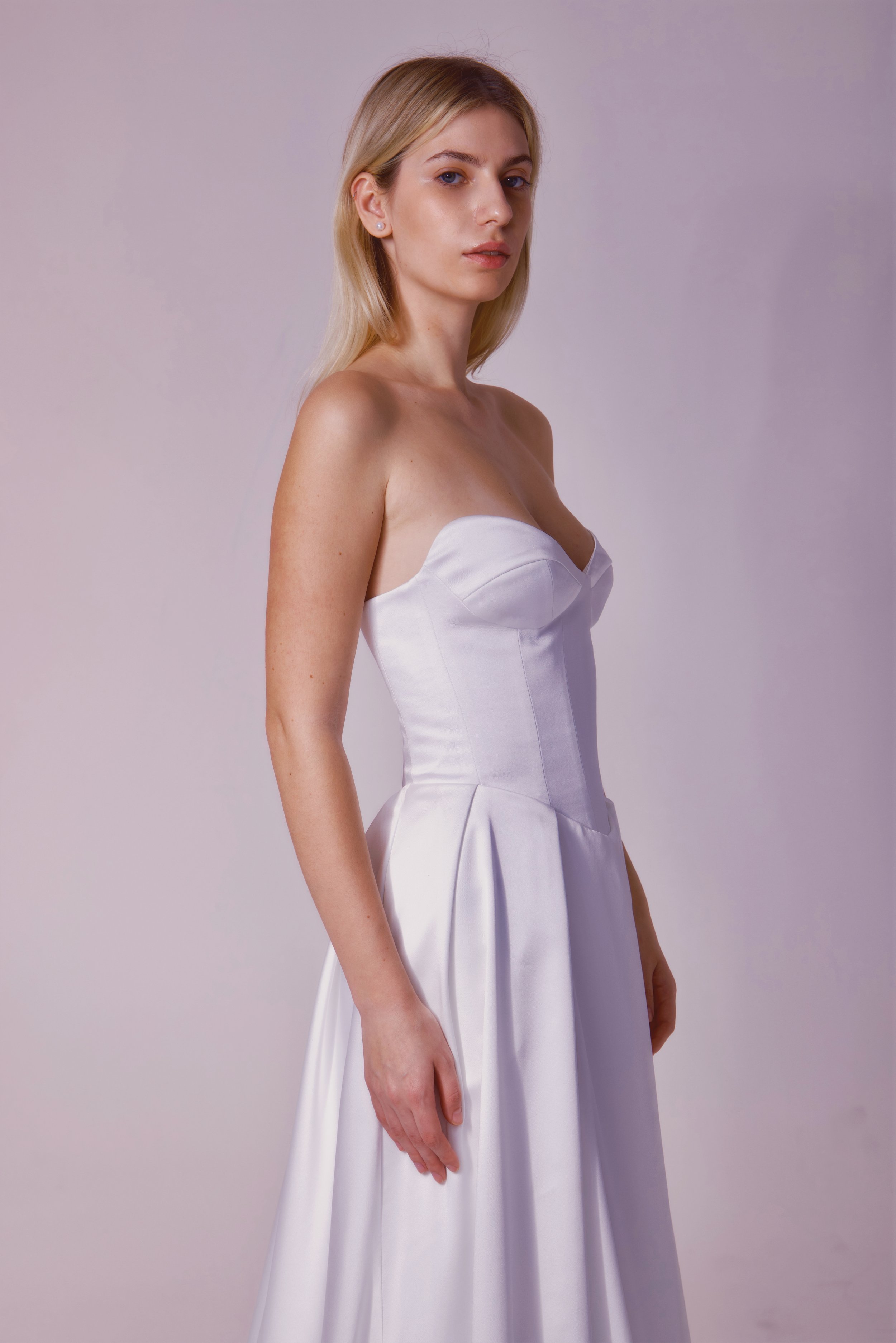 Basque waist, strapless, and a sexy leg slit. This minimalist gown is known for being comfortable and flattering!