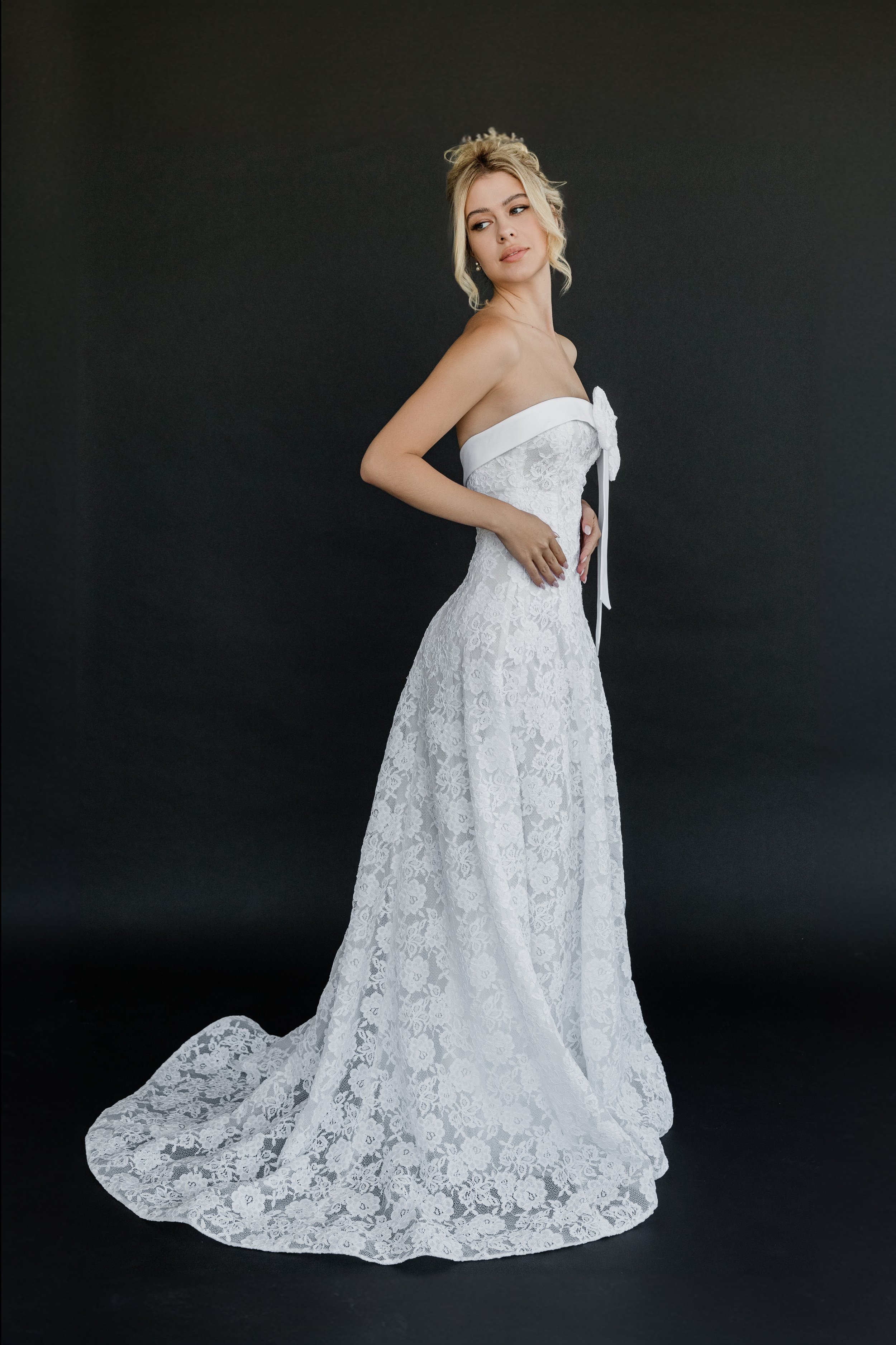 Gown "Daffodil" is crafted from stunning corded floral lace, delicate organza, and soft satin bridal lining. Featuring a detachable bow detail, its fitted bodice gently transitions into a flowing skirt, creating a look that is both sweet and distinct