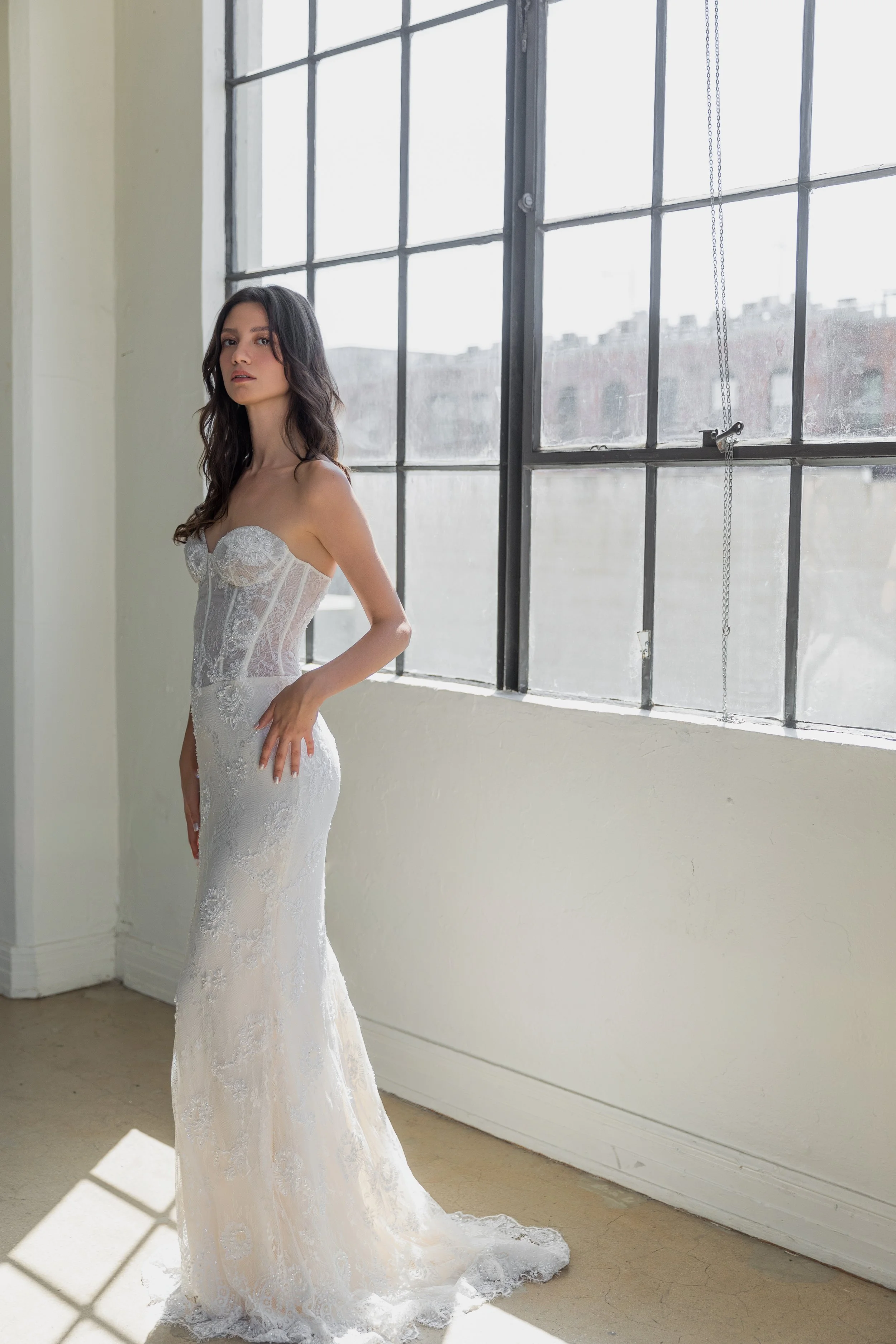 Gown "Zephyr" is crafted from beaded Chantilly lace and soft georgette, offering a fitted silhouette that feels both sexy and sophisticated. The strapless bodice features structured boning for added support, while subtle sparkle and intricate lace de