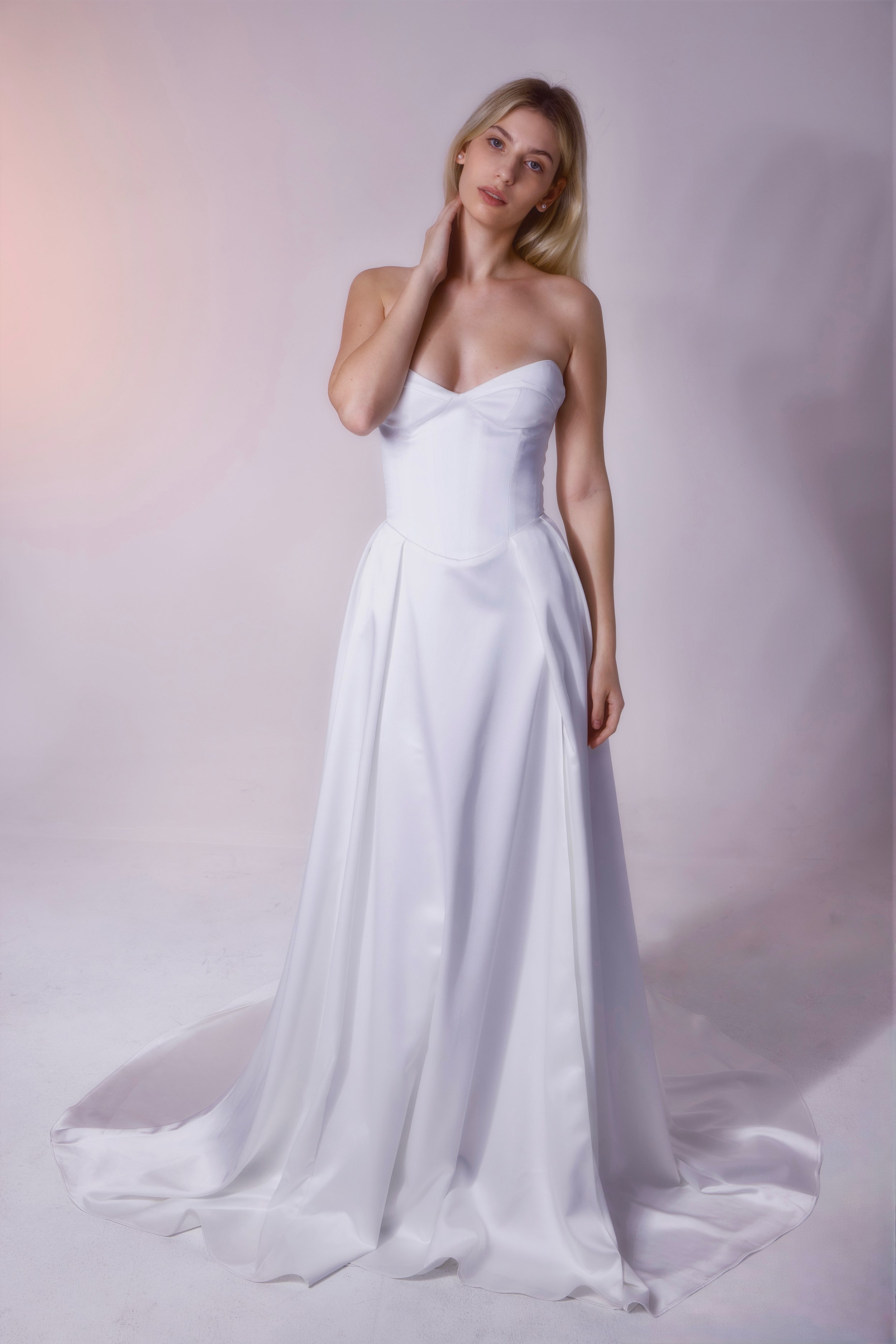 Basque waist, strapless, and a sexy leg slit. This minimalist gown is known for being comfortable and flattering!