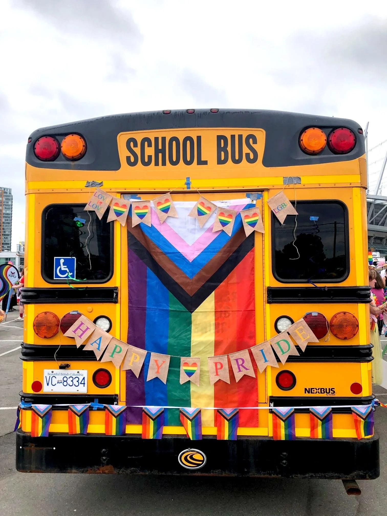 An accessible school bus decorated in Pride flags