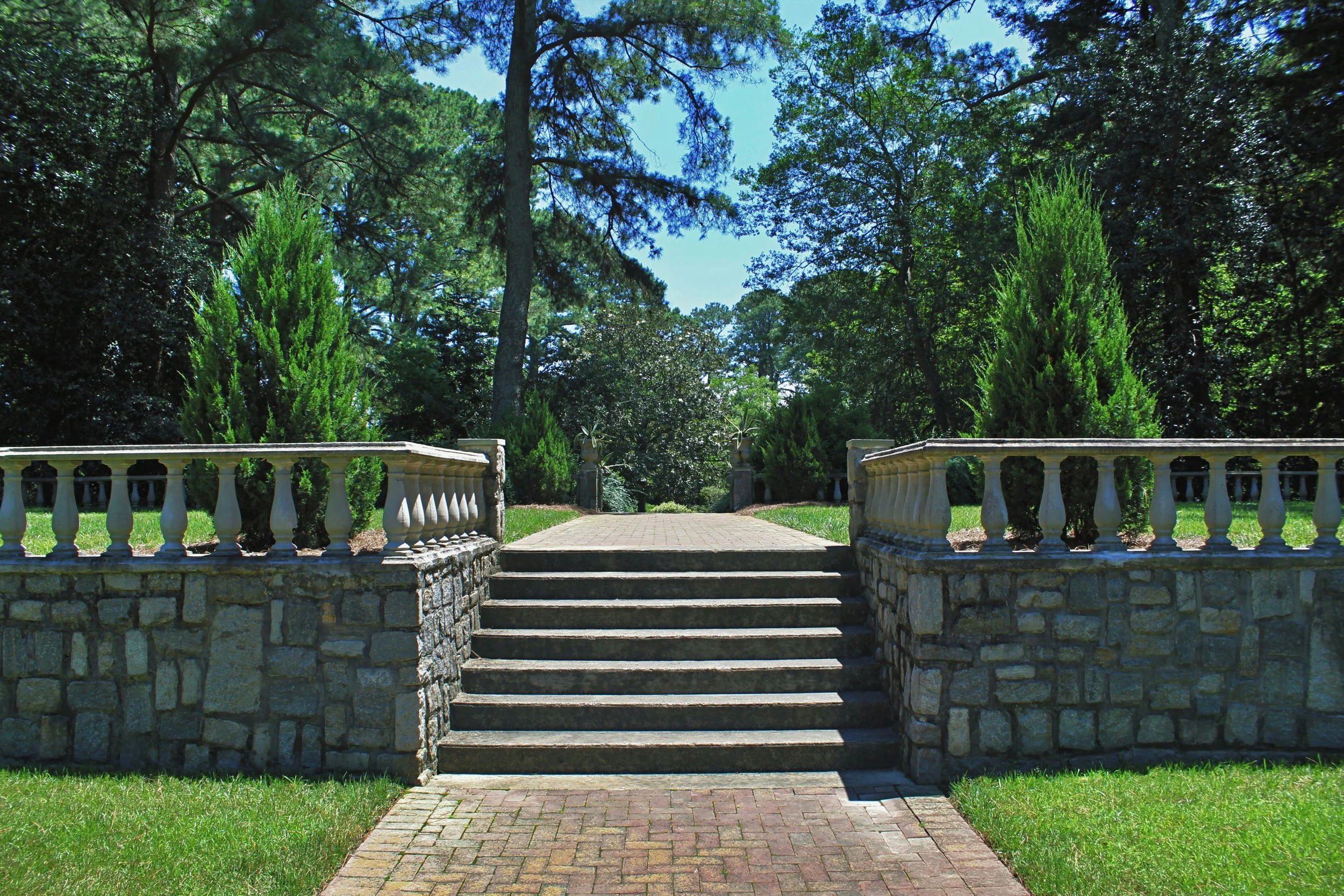 Photo of stone stairs between two trees located in Norfolk Botanical Garden, Azalea Garden Road, Norfolk, VA by Erin Testone on Unsplash