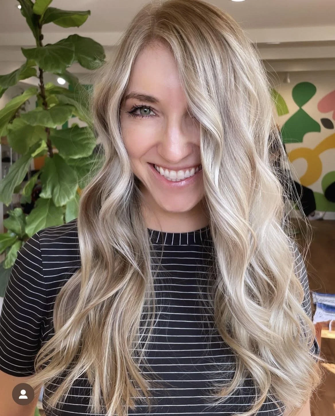 A blonde woman smiles about her new haircolor.