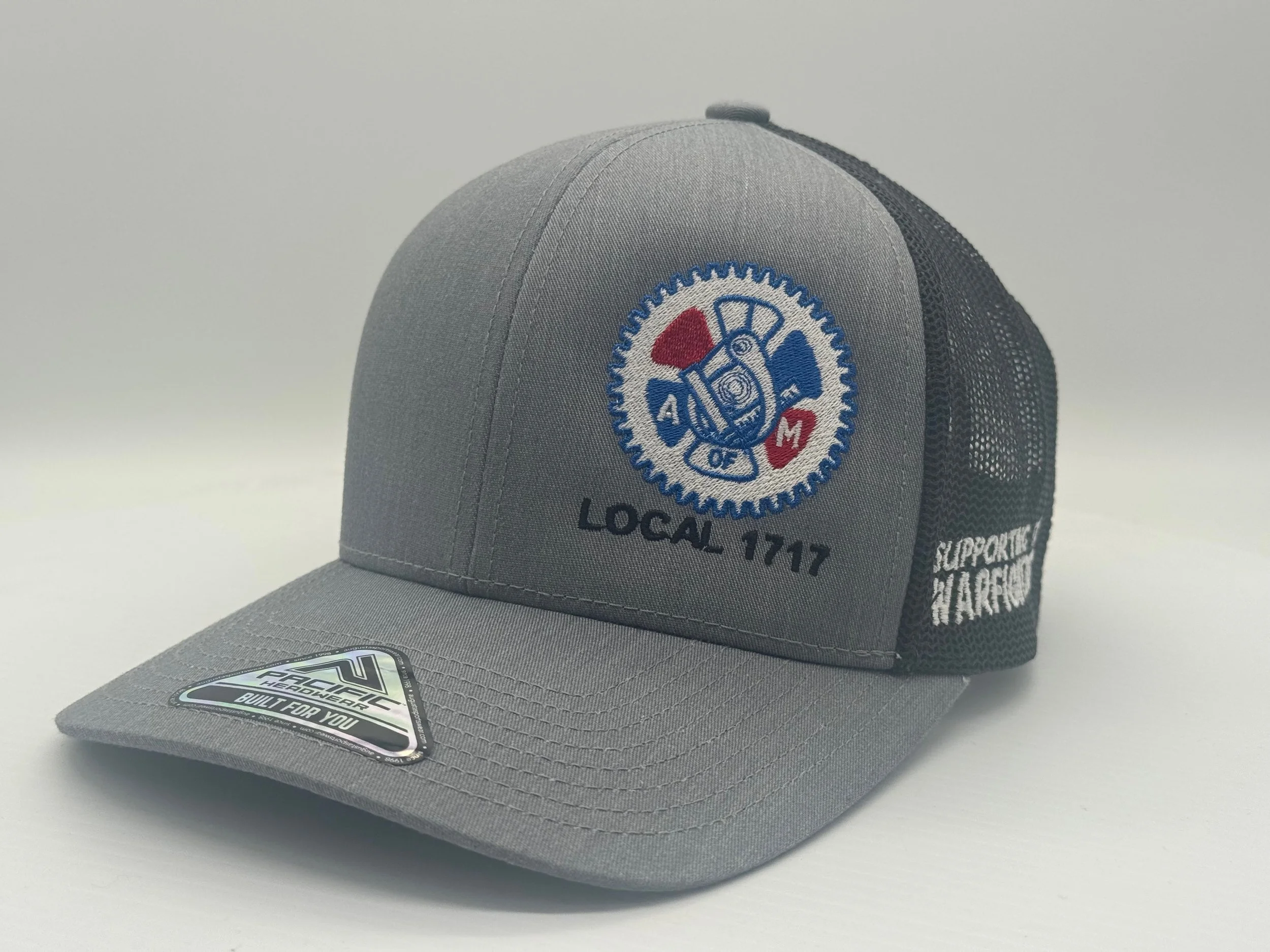 Gray and black trucker hat with a patch featuring a gear and rescue tools, embroidered with 'AOF 1717' and 'LOCAL 1717' on the front, and 'SUPPORT HARBOR' on the side.