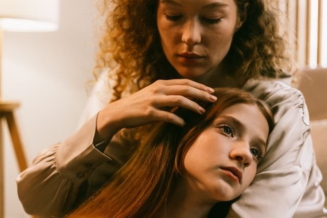 A girl being comforted by her mother