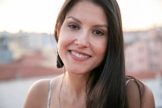 A woman smiling at you with brown long hair
