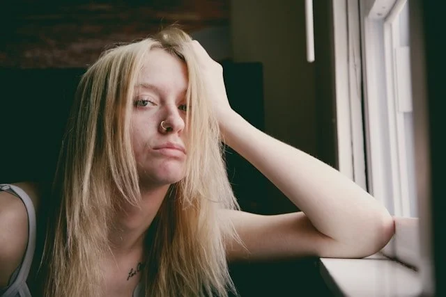 A girl looking frusterated with a nose ring and blond hair