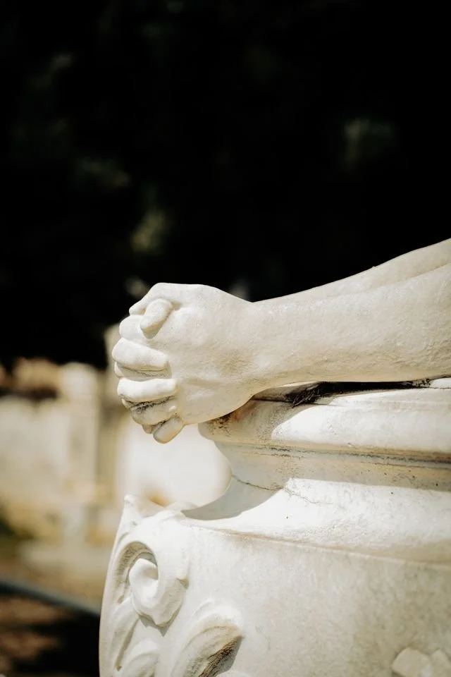 white stone hands clasped in prayer