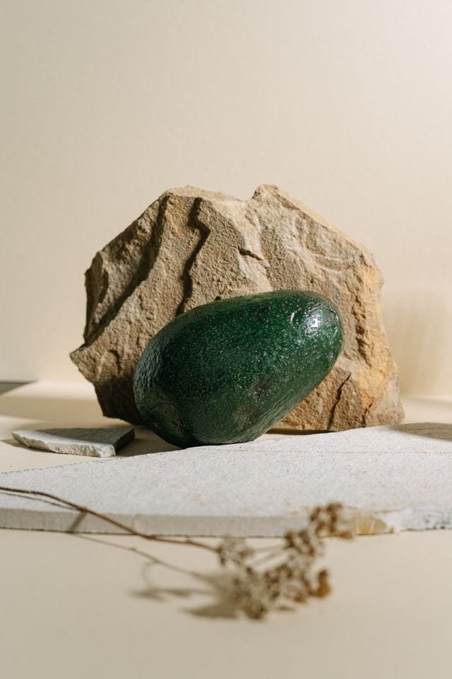 smooth green stone in front of larger jagged stone