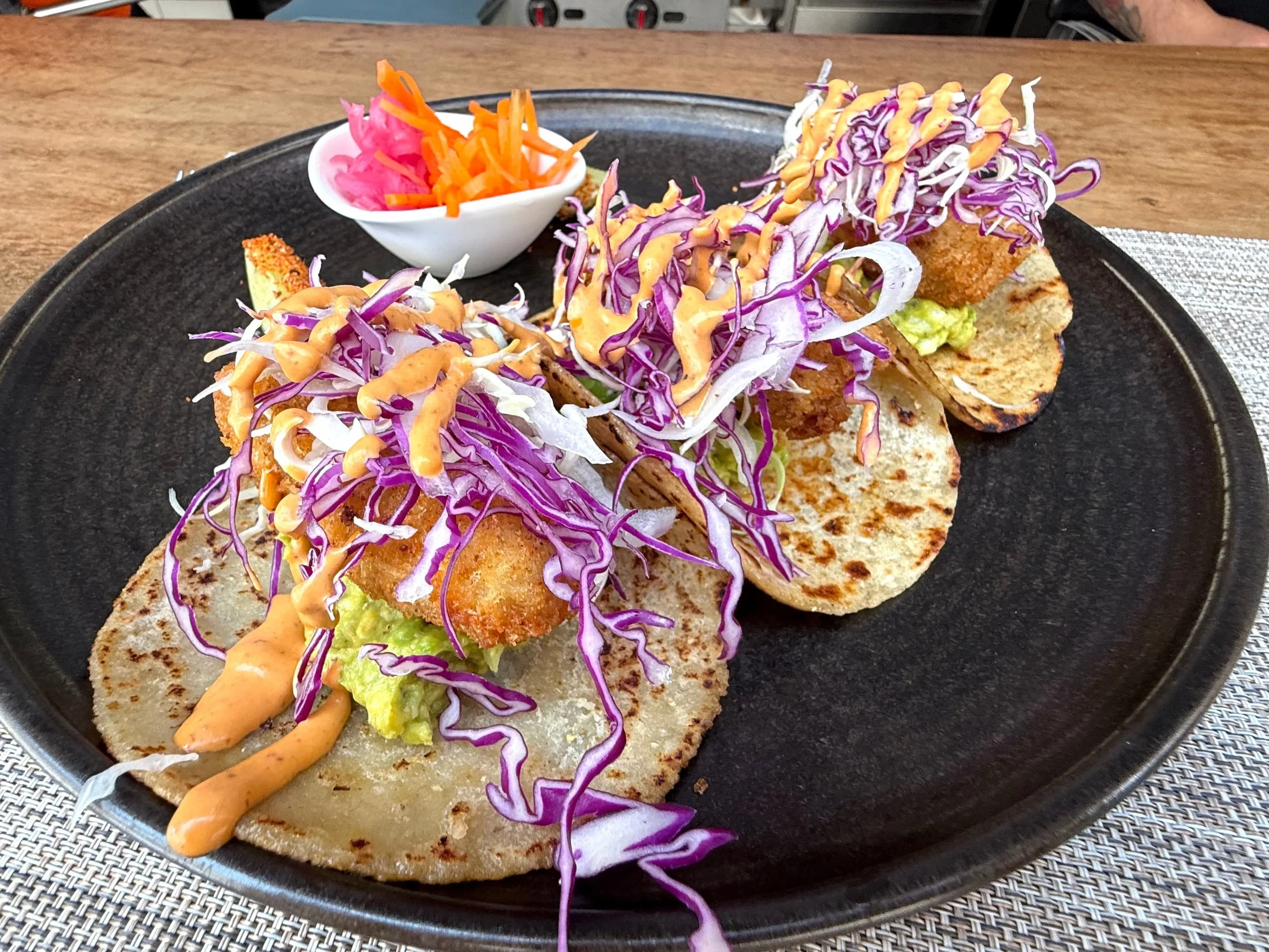 BAJA FISH TACOS ~ fried local fish, guacamole, mixed cabbage, cilantro, spicy chipotle mayo, lime wedge