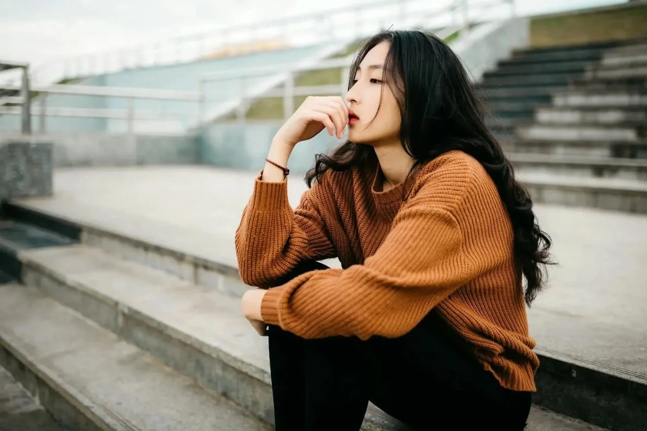 Young woman sitting alone on bleachers
