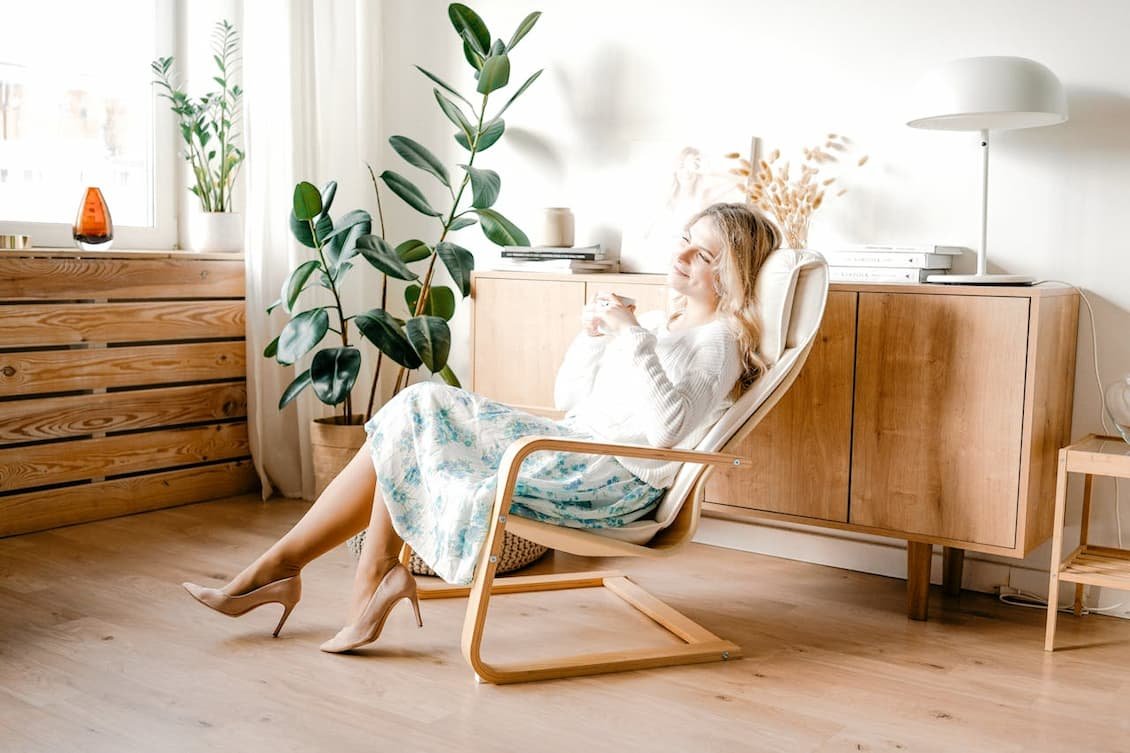 woman-in-white-long-sleeves-and-floral-skirt-sitting-on-a-wooden-chair