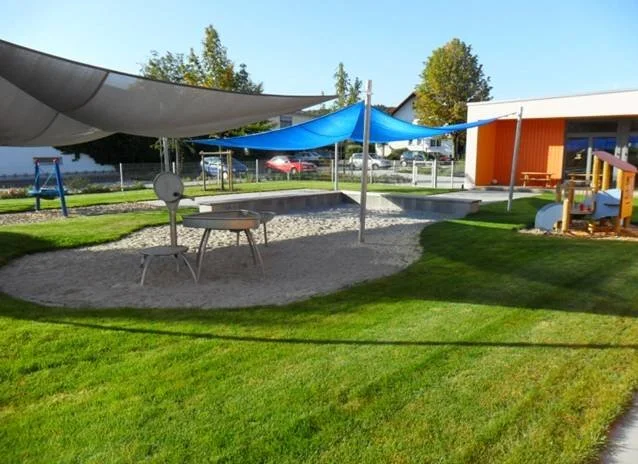 Spielplatz mit großem Sandkasten im Garten der Fliegerkiste